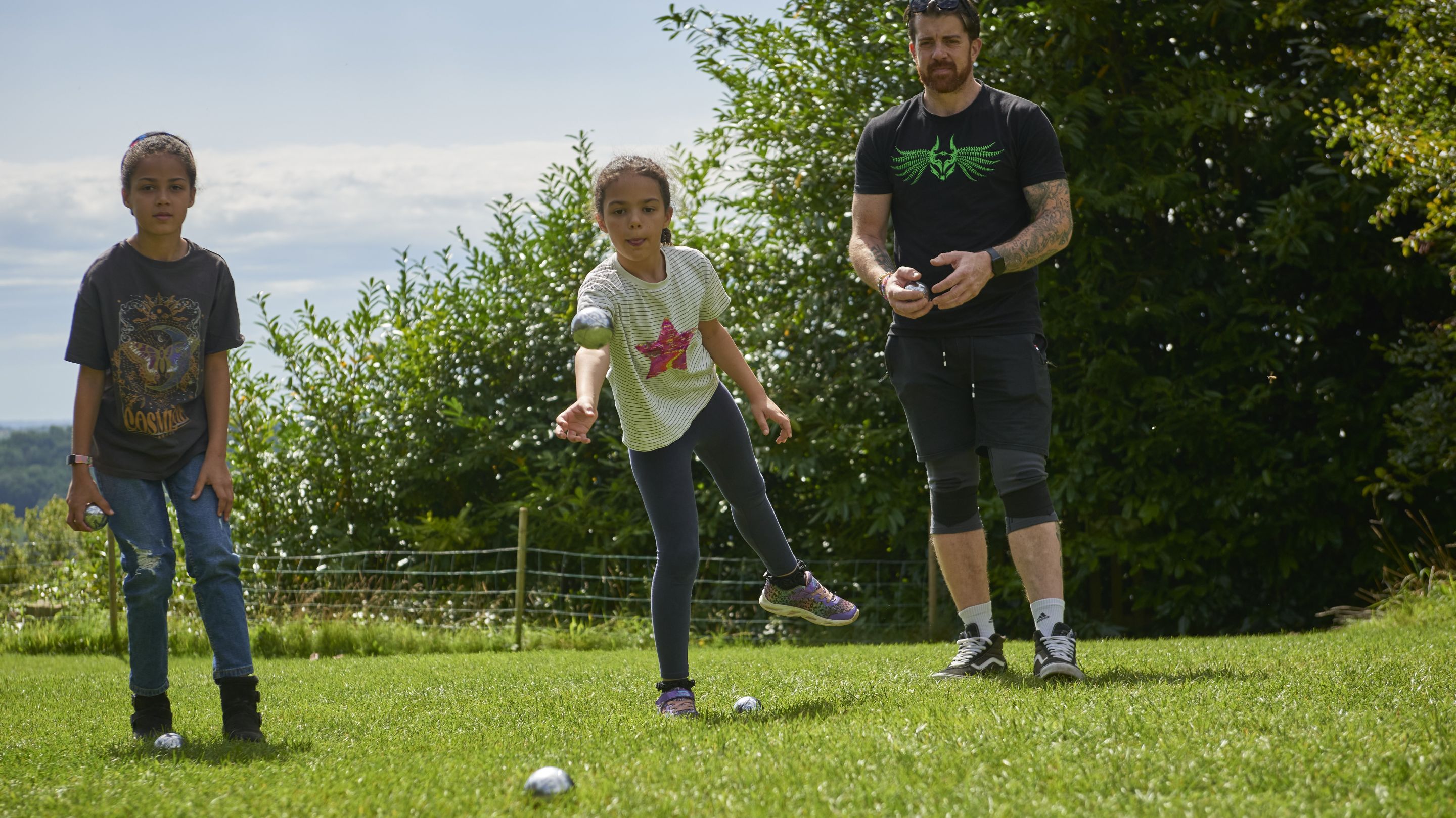 A family playing boules in the garden at Newark Park, Gloucestershire 