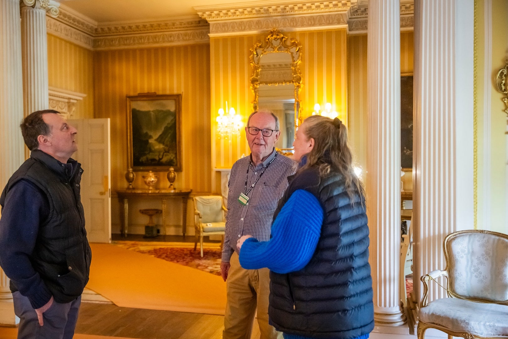 Volunteer room guide speaking to visitors at Hinton Ampner