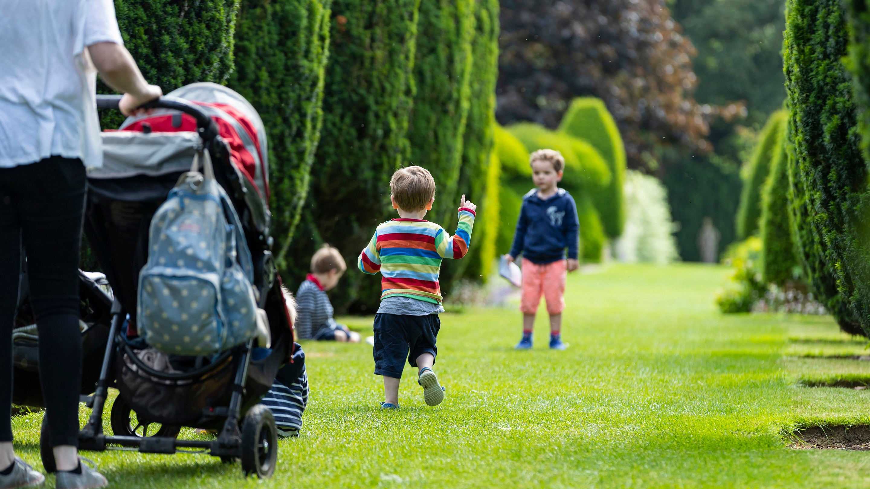 Children are seen playing in the Yew Avenue in June at Hinton Ampner, Hampshire