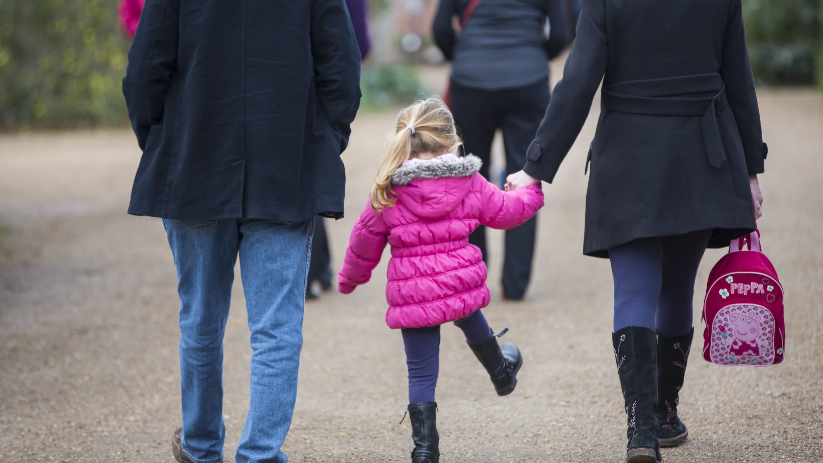 Visitors walking at Hinton Ampner, Hampshire with a young child between them