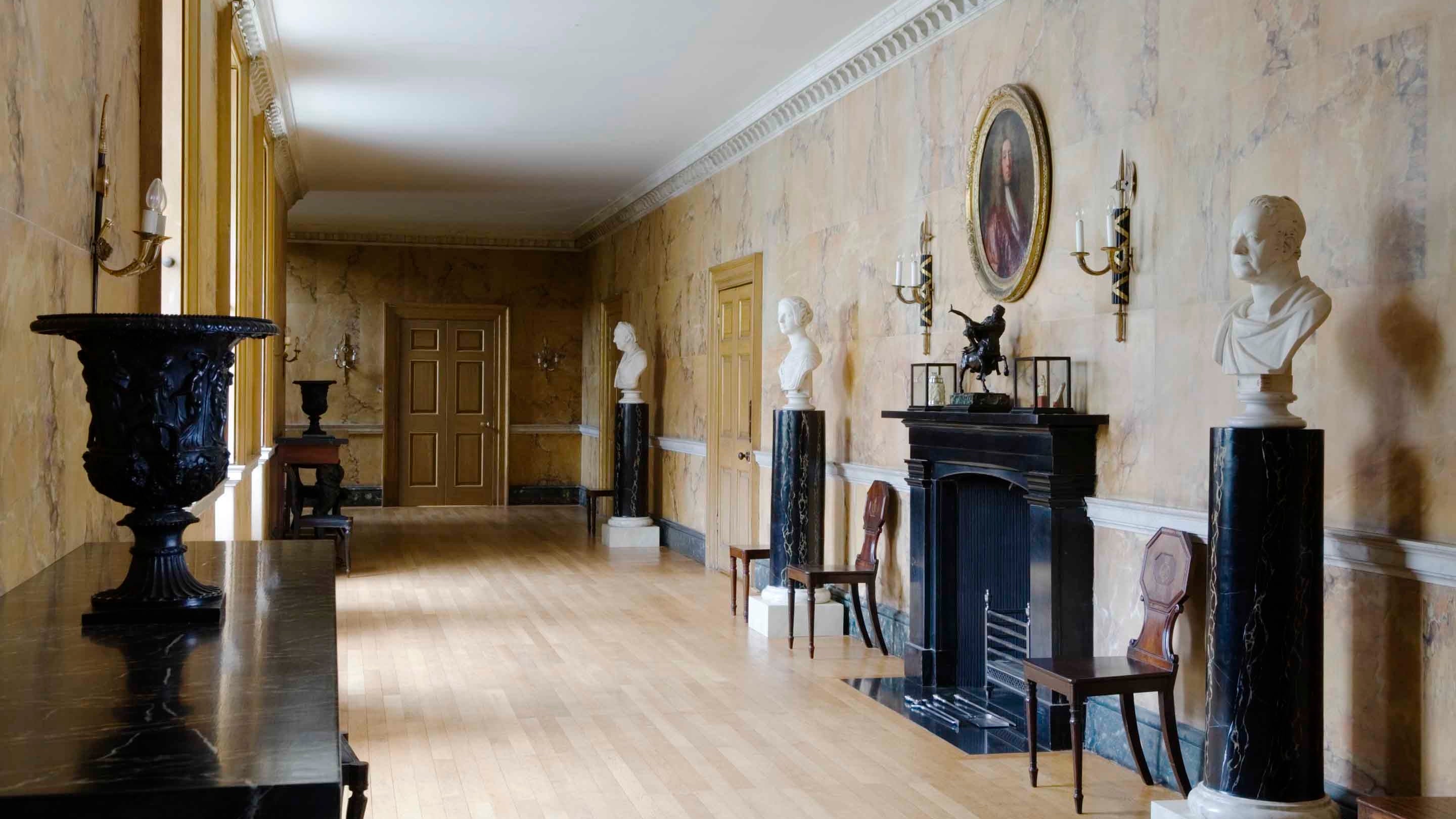 Busts on pillars in The Long Gallery, Mottisfont, Hampshire. It was installed in the 1740s and used as an indoor exercise space for ladies. The walls are painted to simulate Sienna marble.