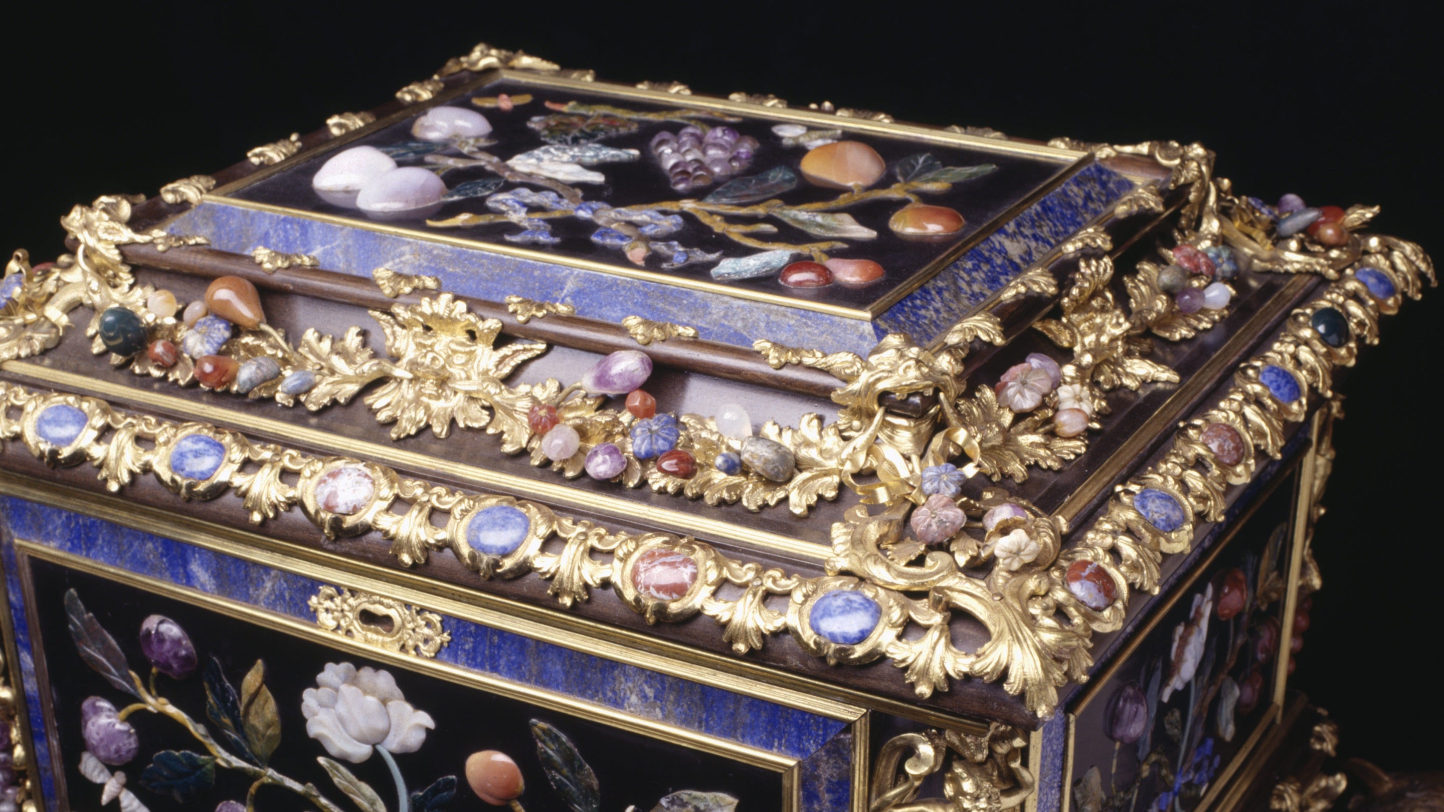 A detailed close up of an 18th-century casket of ebony with panels of pietra dura mounted in ormolu and encrusted with semi-precious stones