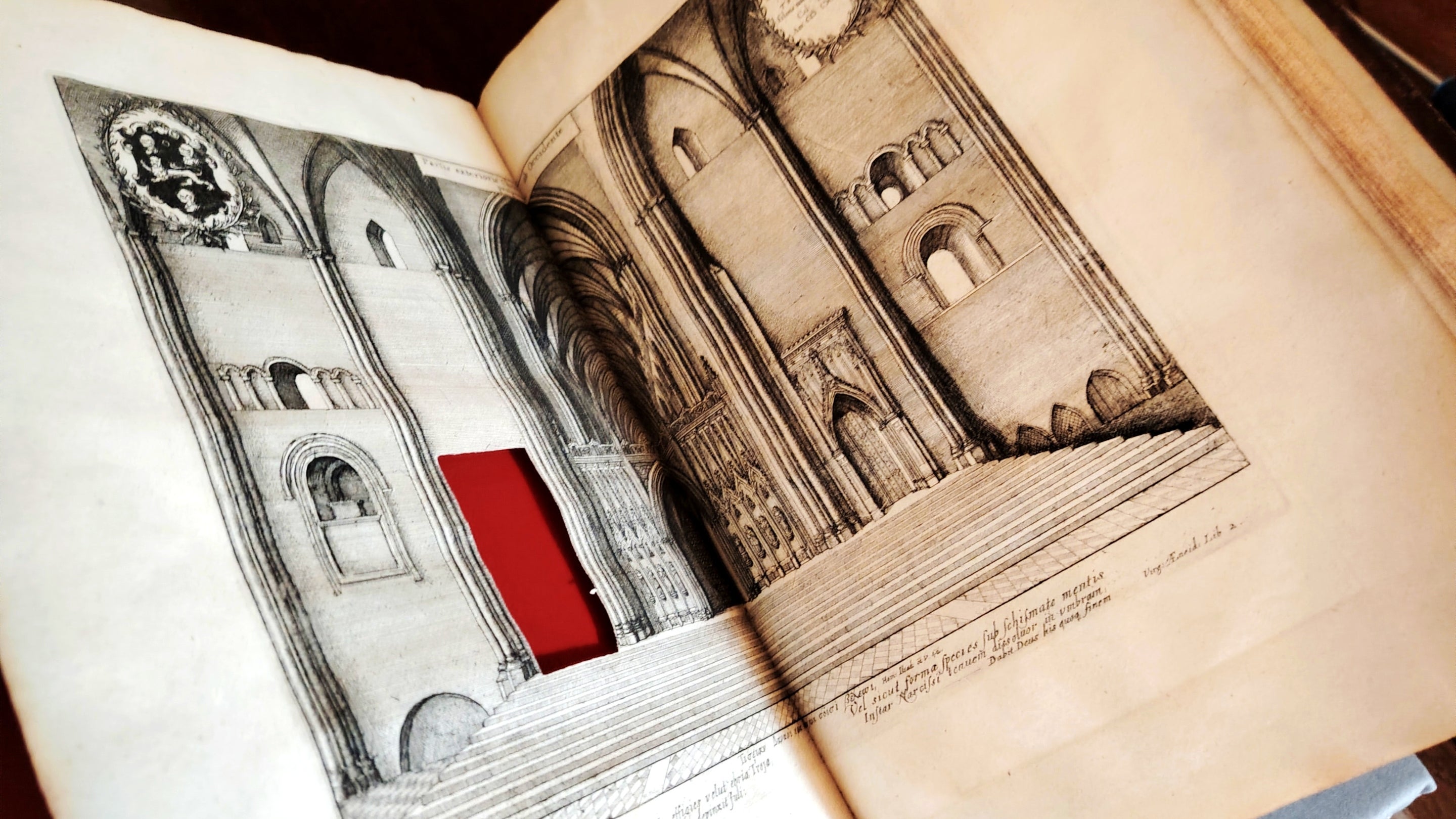 A book lies open revealing a rectangle cut from the page.