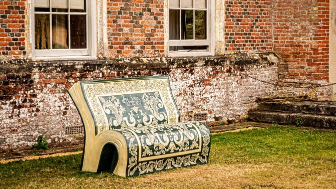 A bench in the shape of a book decorated by an artist.