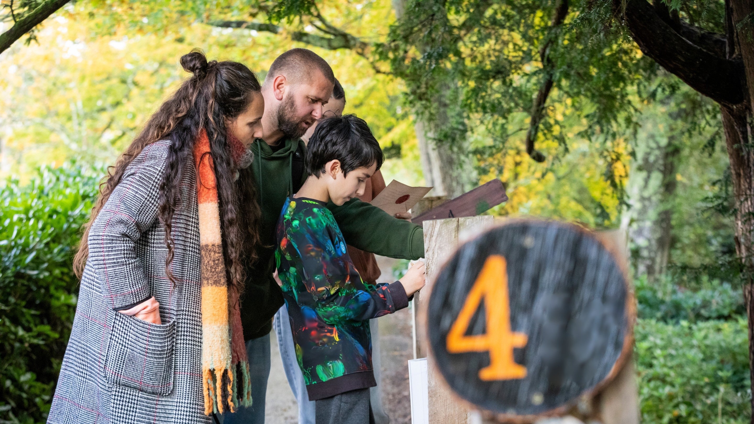 A family try to work out a puzzle in a garden trail.