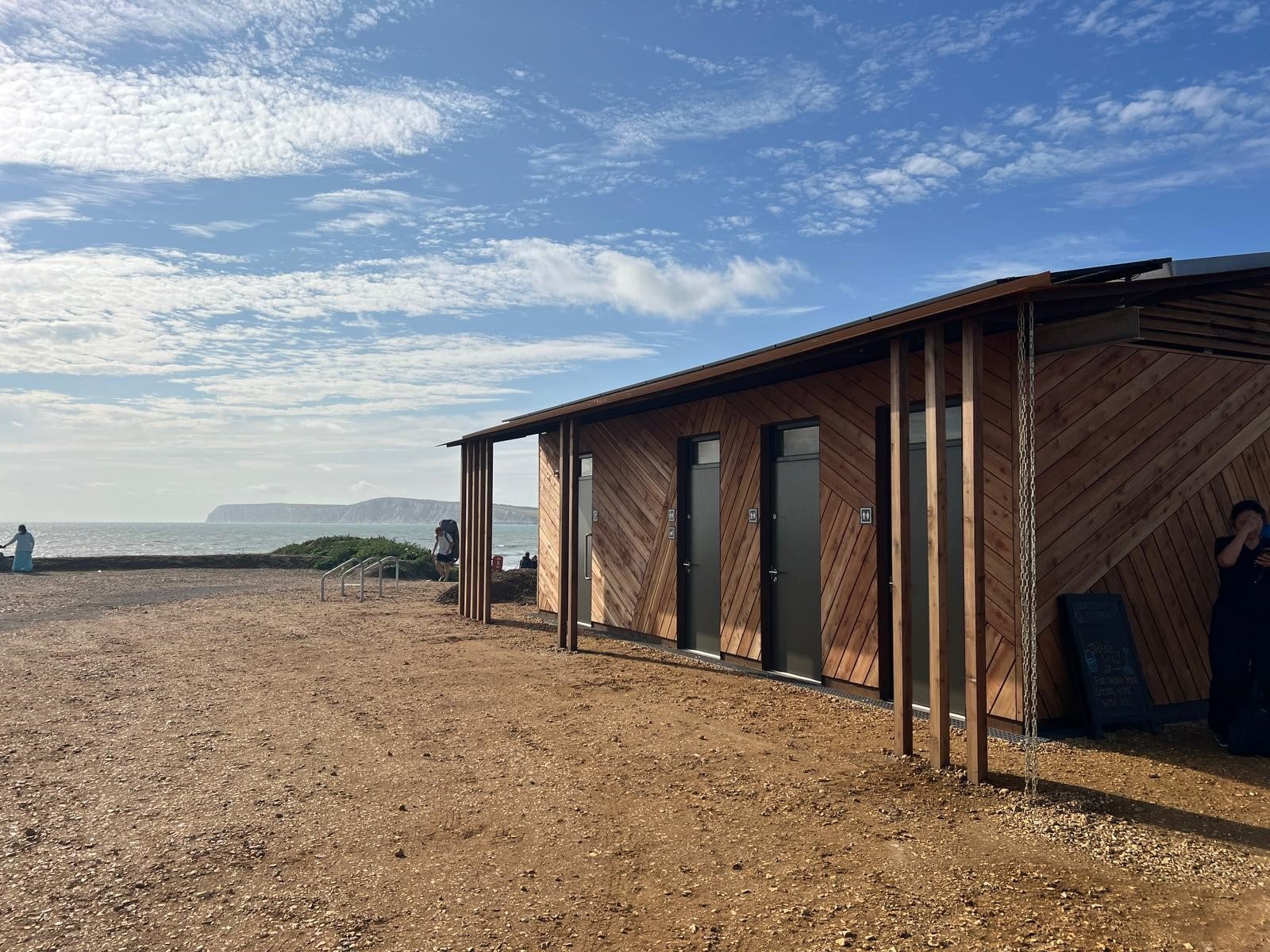Image of toilet block with sedum roof and background of cliffs