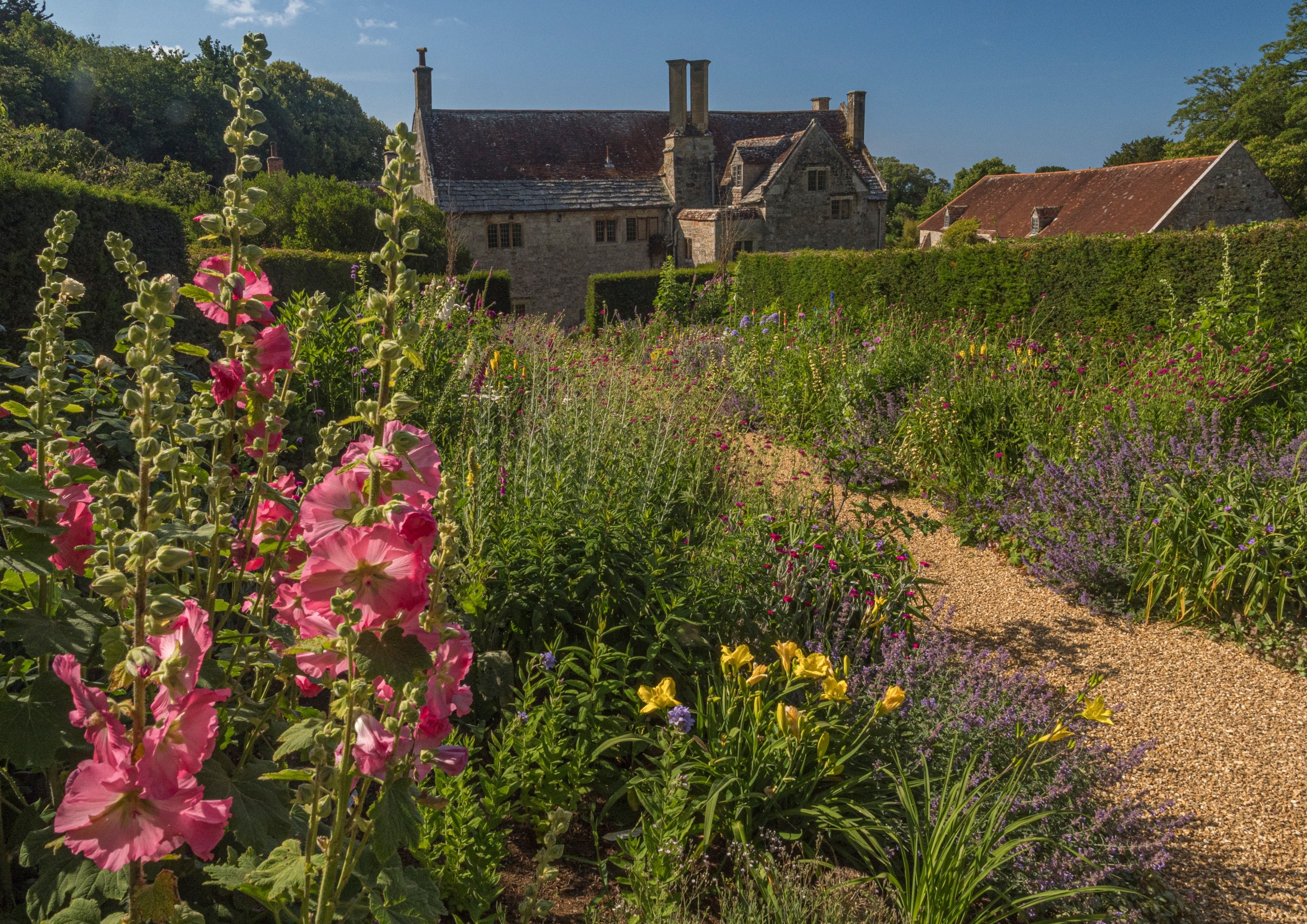 Double colourful flower borders looking down to Manor House