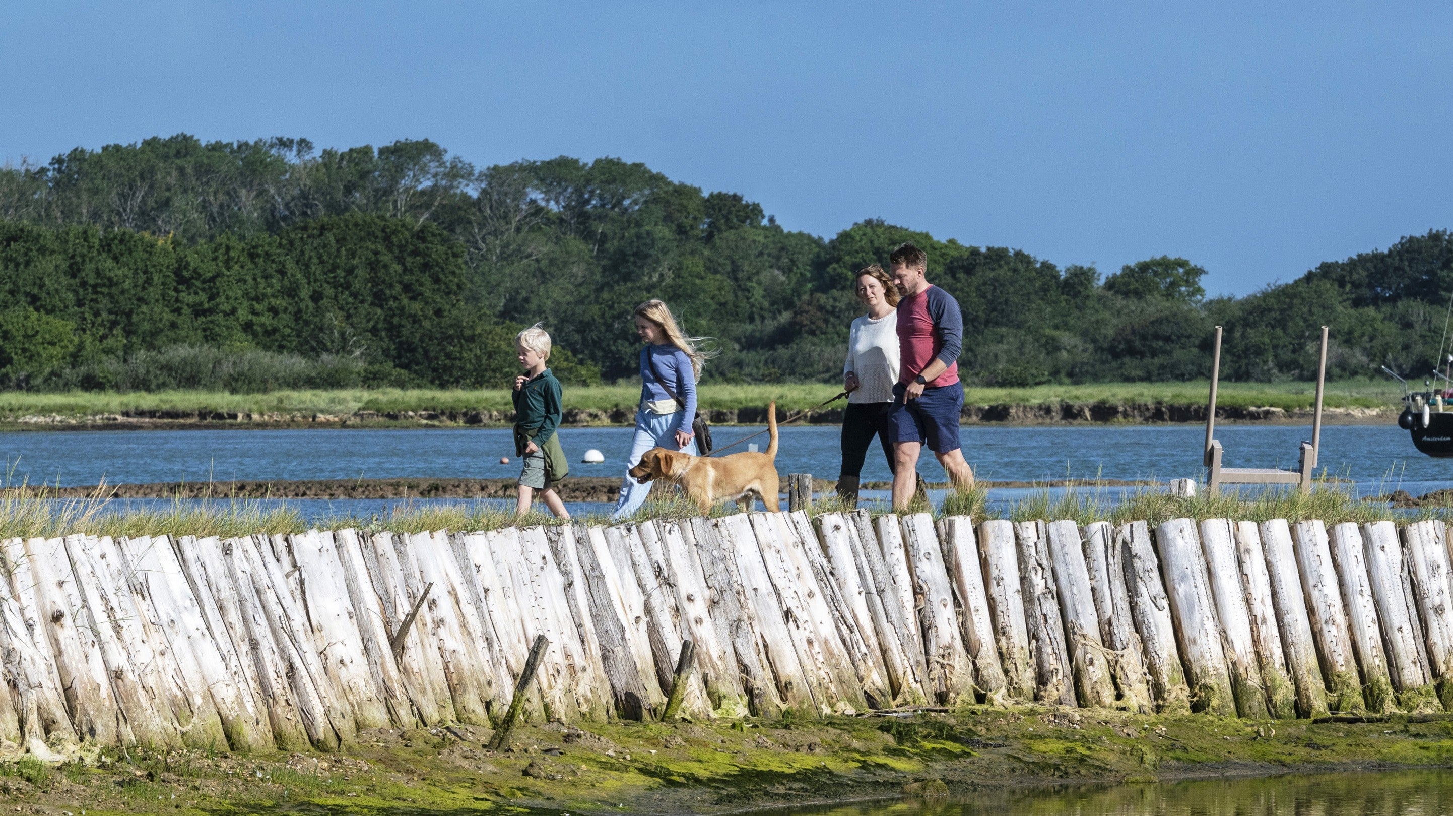 Family walking with dog around the salt pans at Newtown National Nature Reserve Isle of Wight