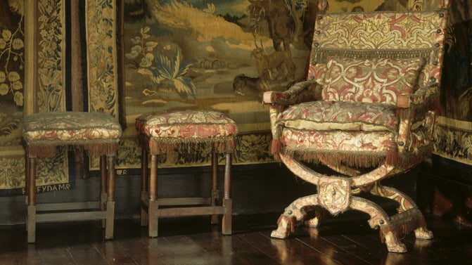 A close up of an X-framed 'Chair of State' and two high stools, in the Spangle Bedroom at Knole, Kent