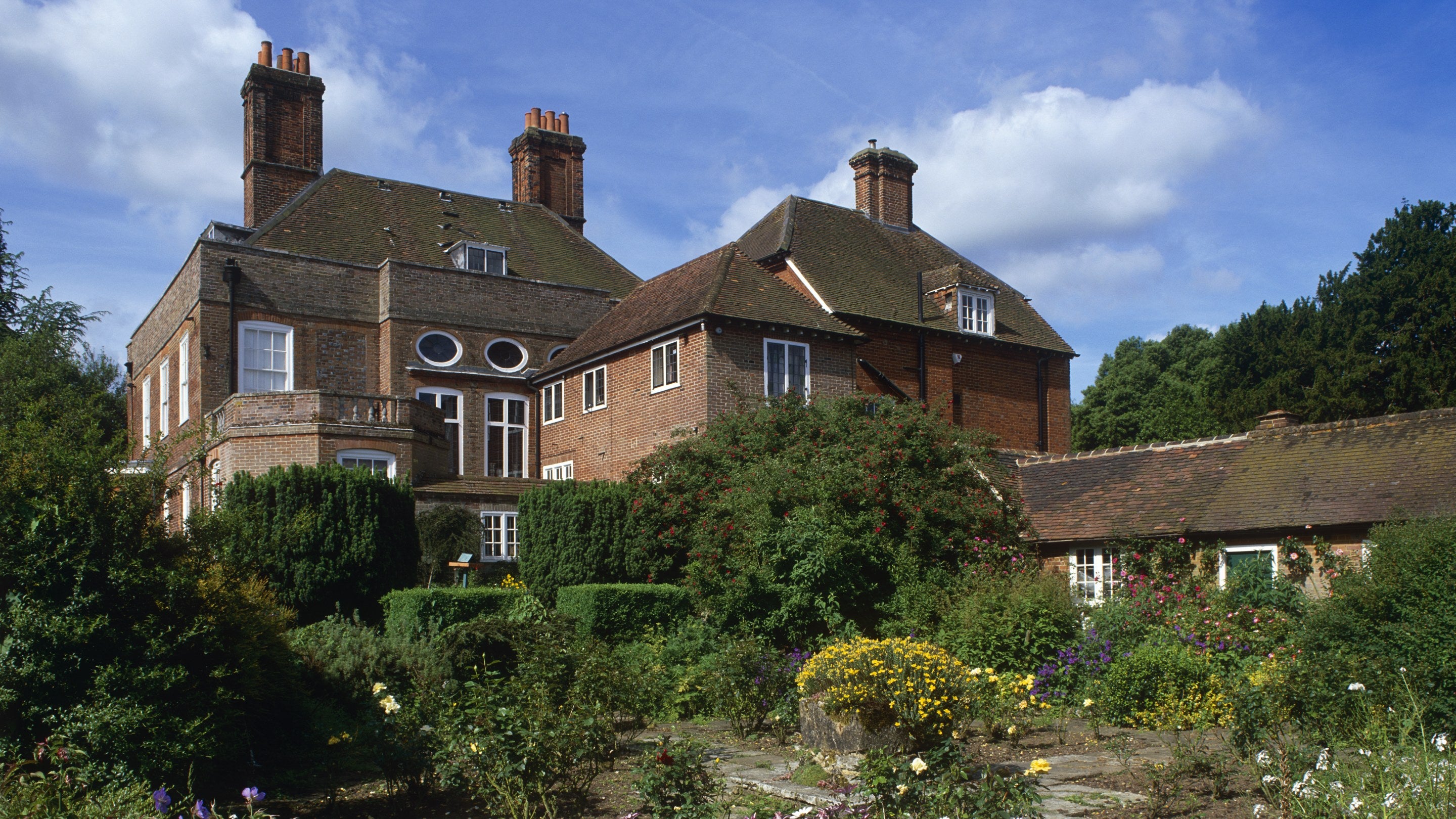 View across garden to the house, Owletts, near Cobham, Kent, with Osteospermum flowering in foreground