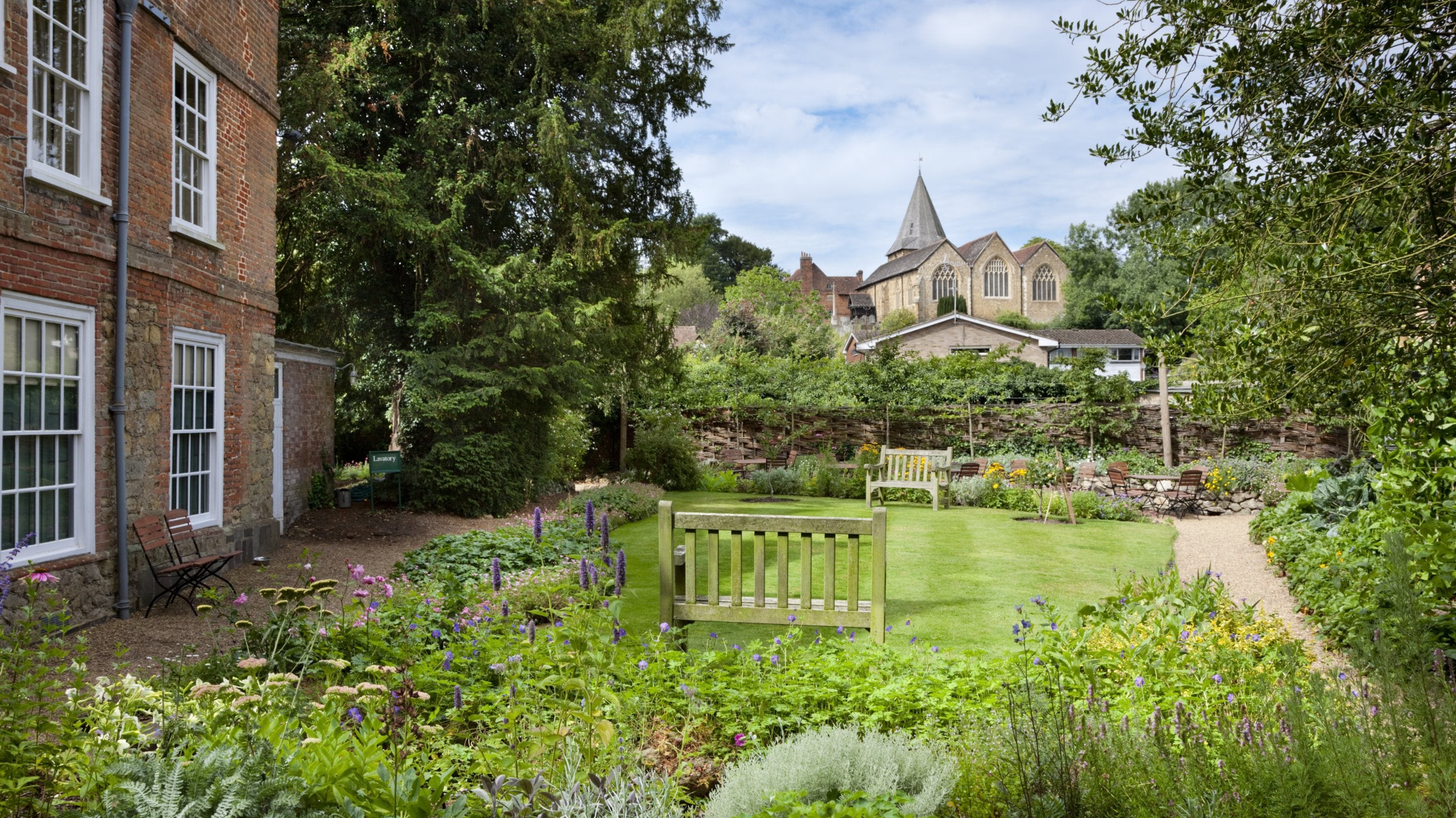 View from the east lawn across the rear lawn to the Church (not National Trust) at Quebec House, Westerham, Kent