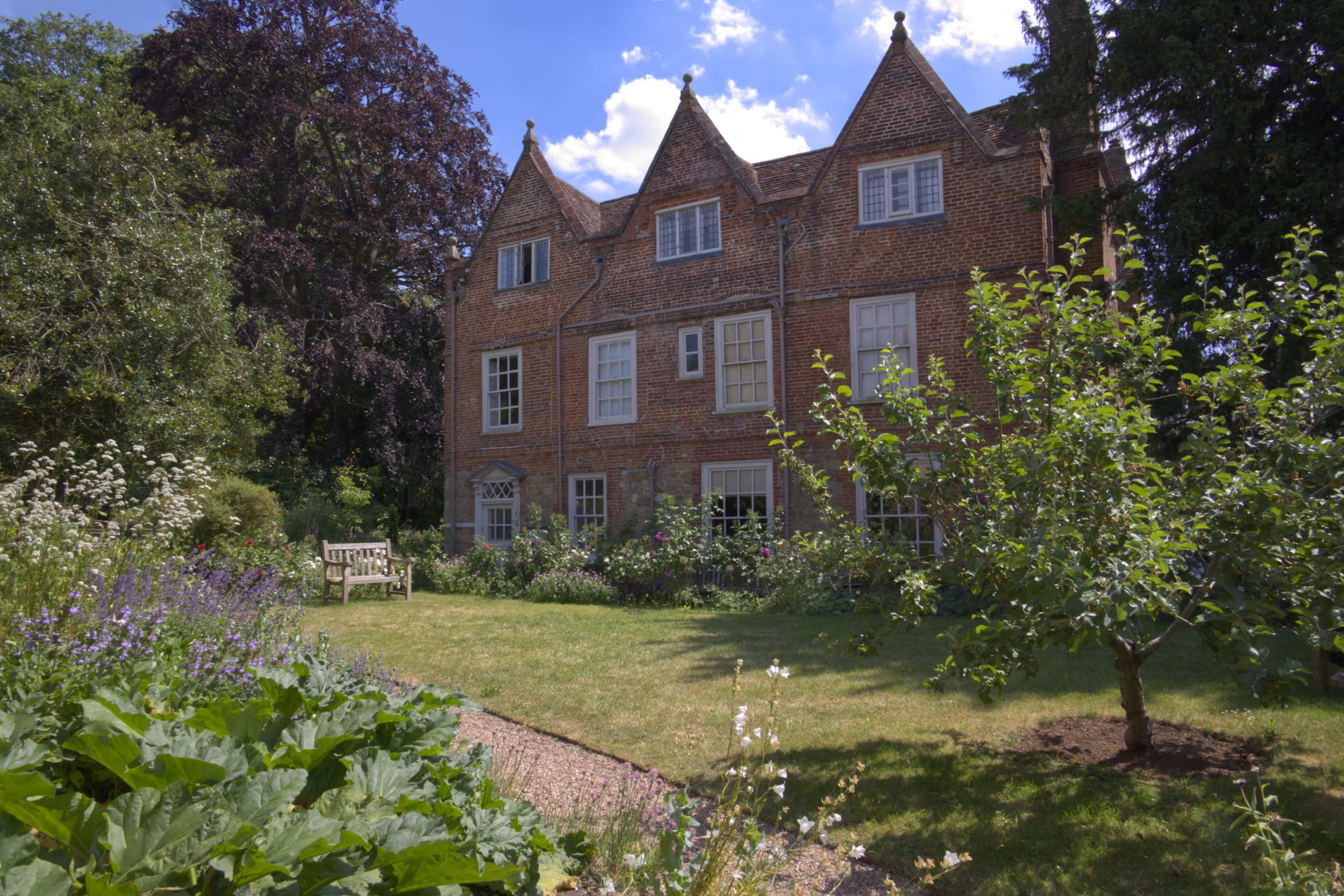 Early Summer Scene at Quebec House, Kent. Apple tree and flowers in the garden.