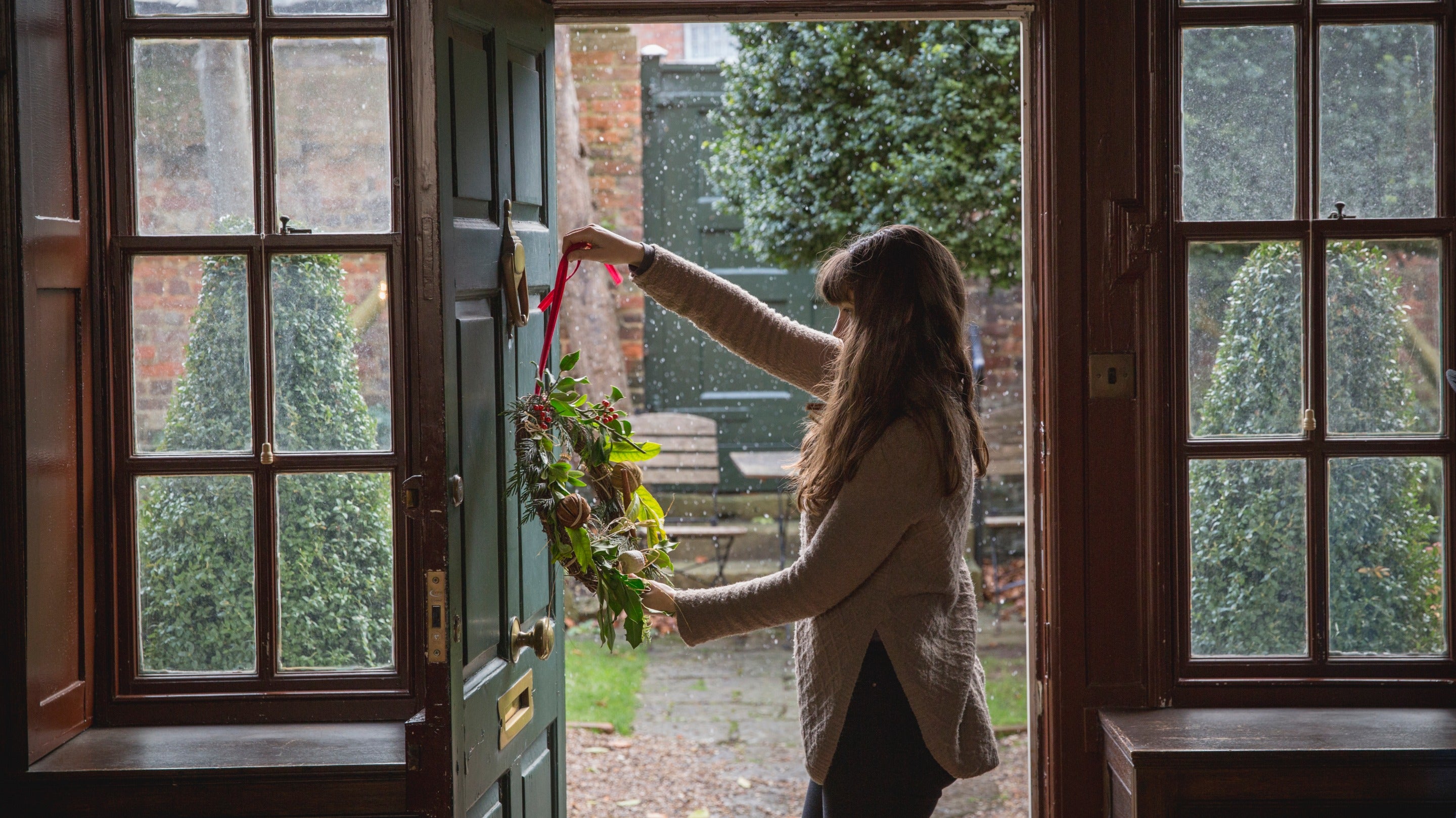 Christmas wreath being placed on a door at Quebec House, Kent
