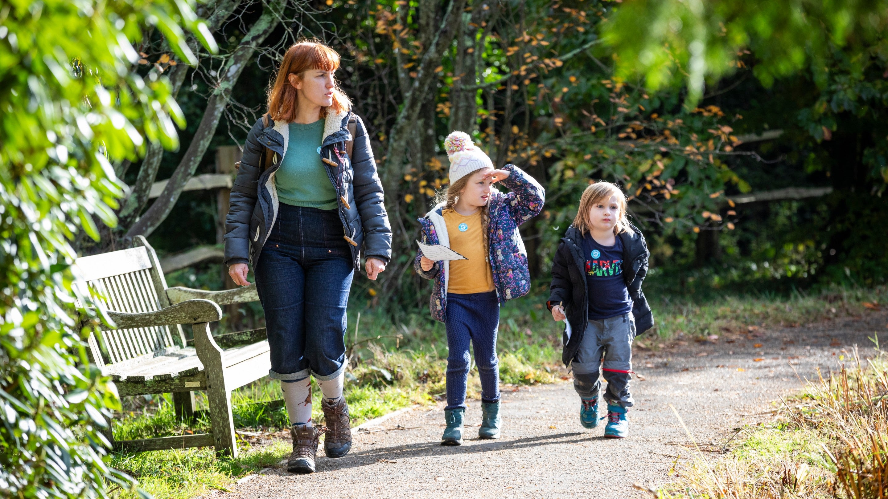 A woman and two children walking down a path towards the camera