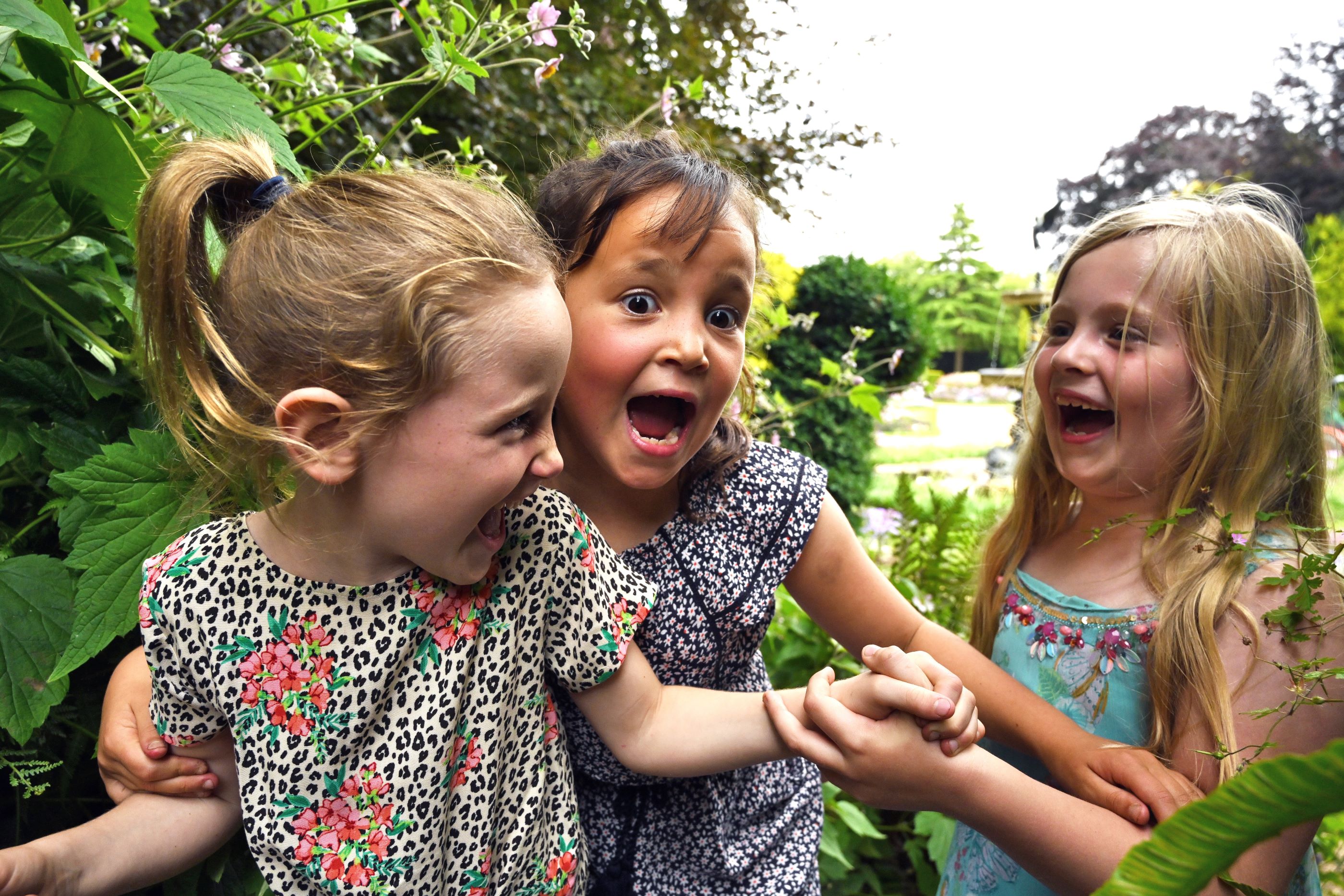 Three happy laughing girls in a garden