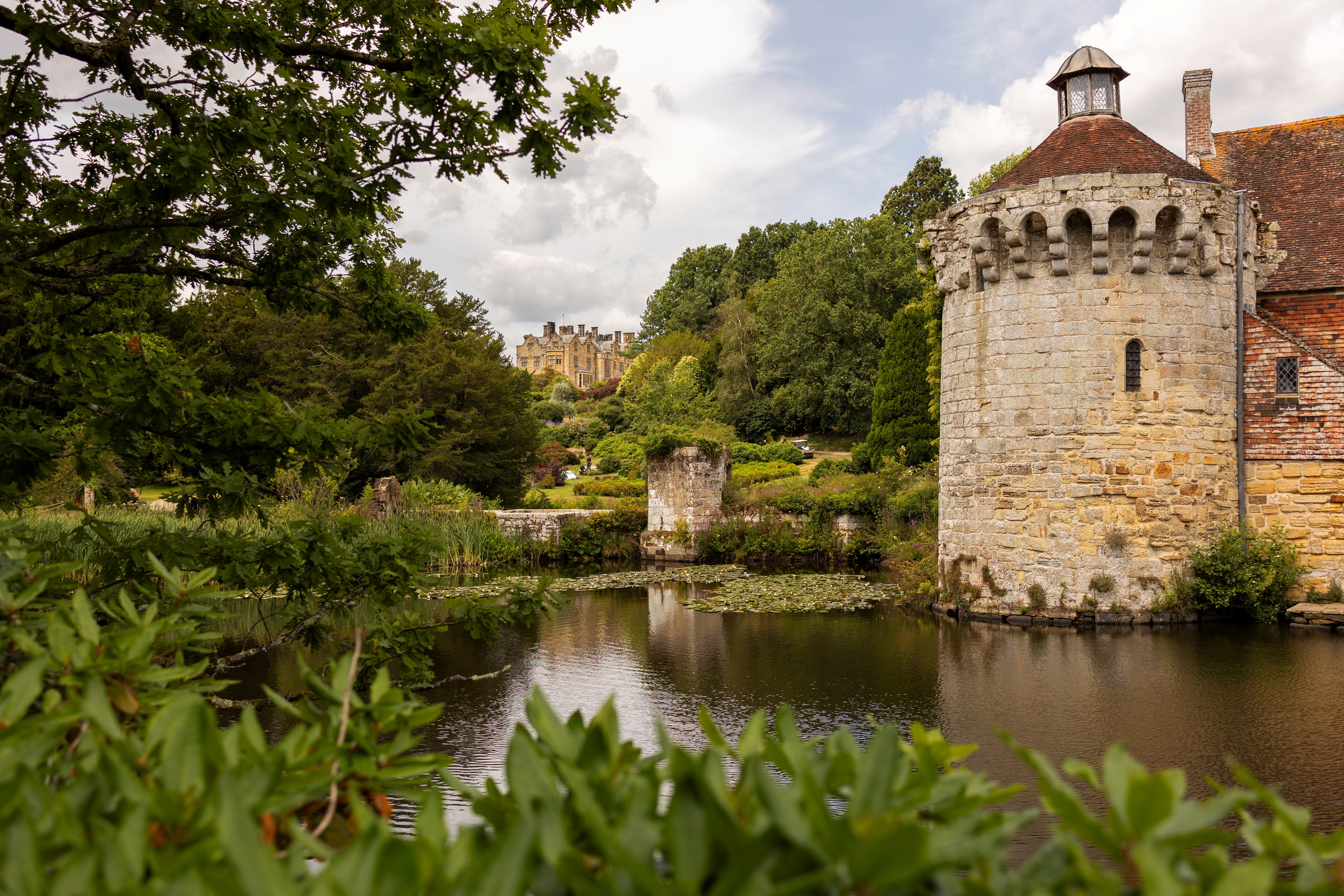 View across the moat of the Old Castle ruins towards the Victorian house at Scotney Castle, Kent
