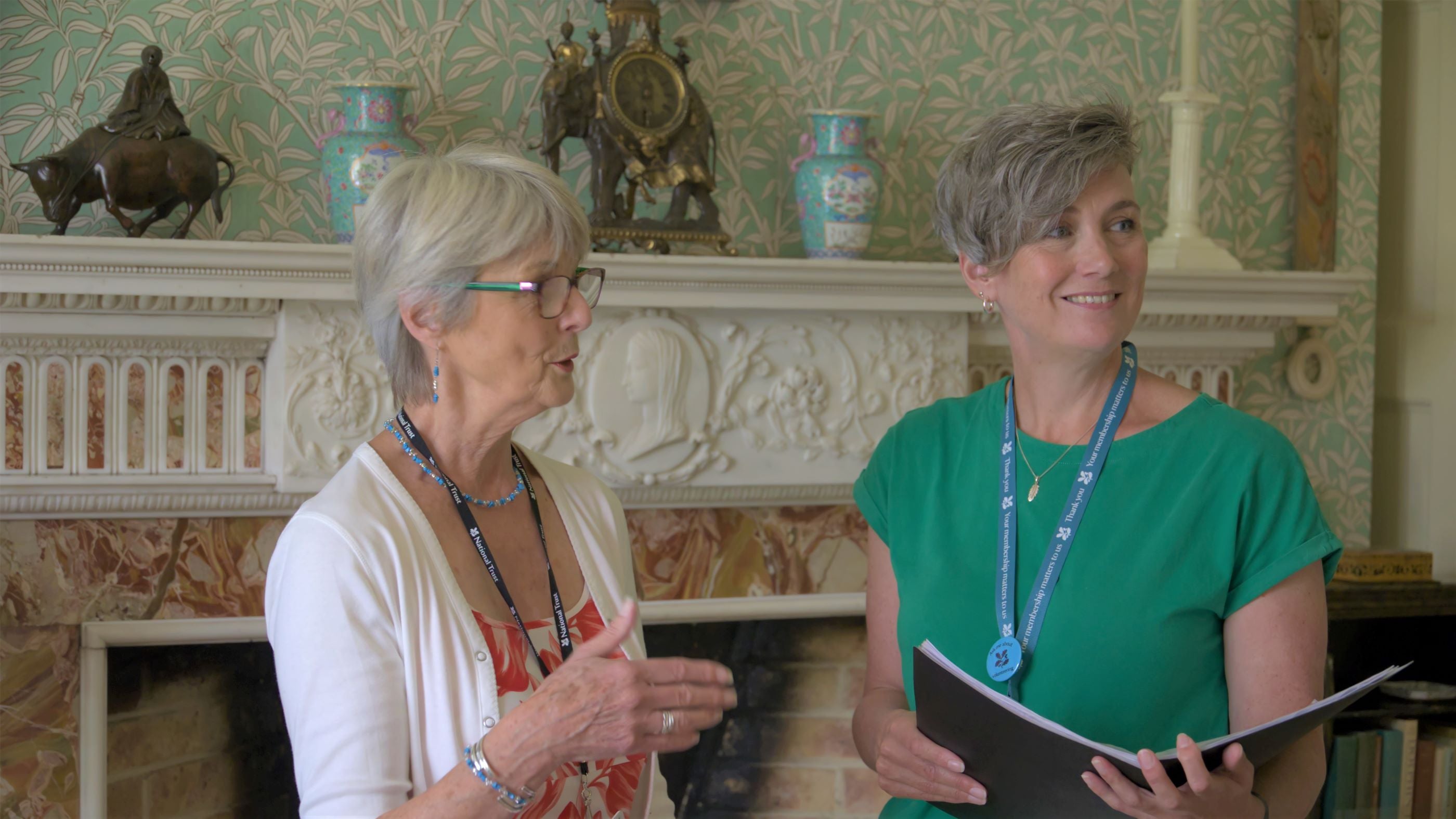 Two adults standing in front of a fireplace