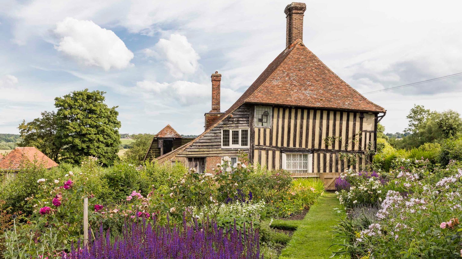The house and garden at Smallhythe Place showing flowers in bloom in June