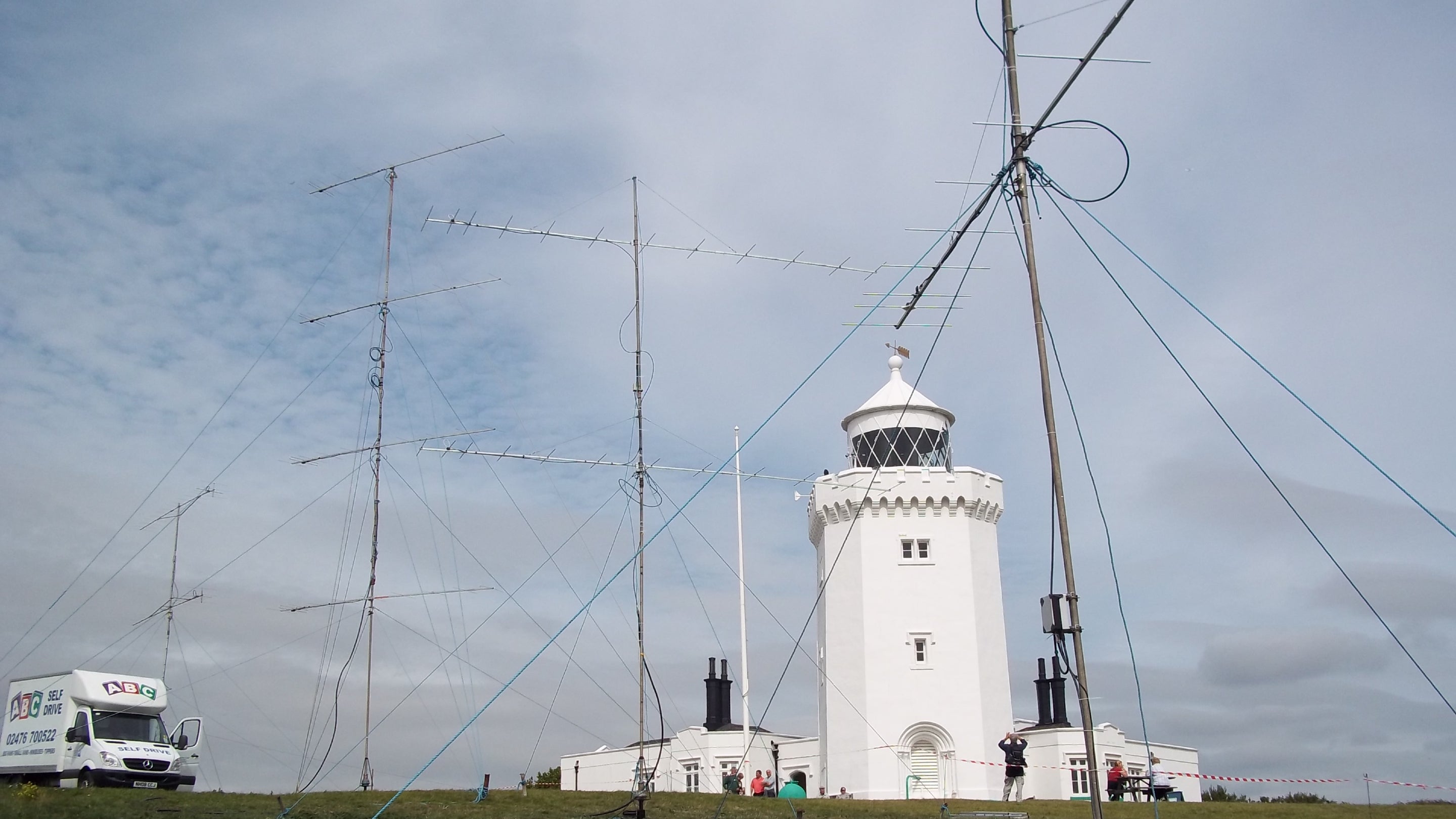 Image of South Foreland Lighthouse surrounded by radio aerials on a partly cloudy day