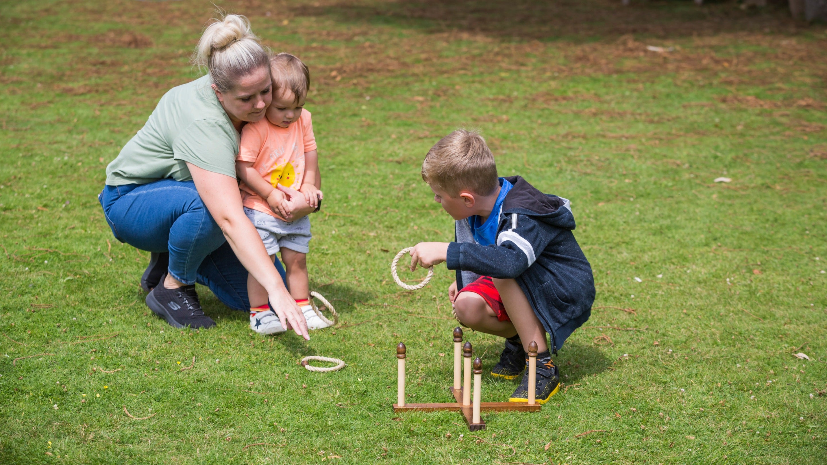 A young girl playing quoits on a lawn