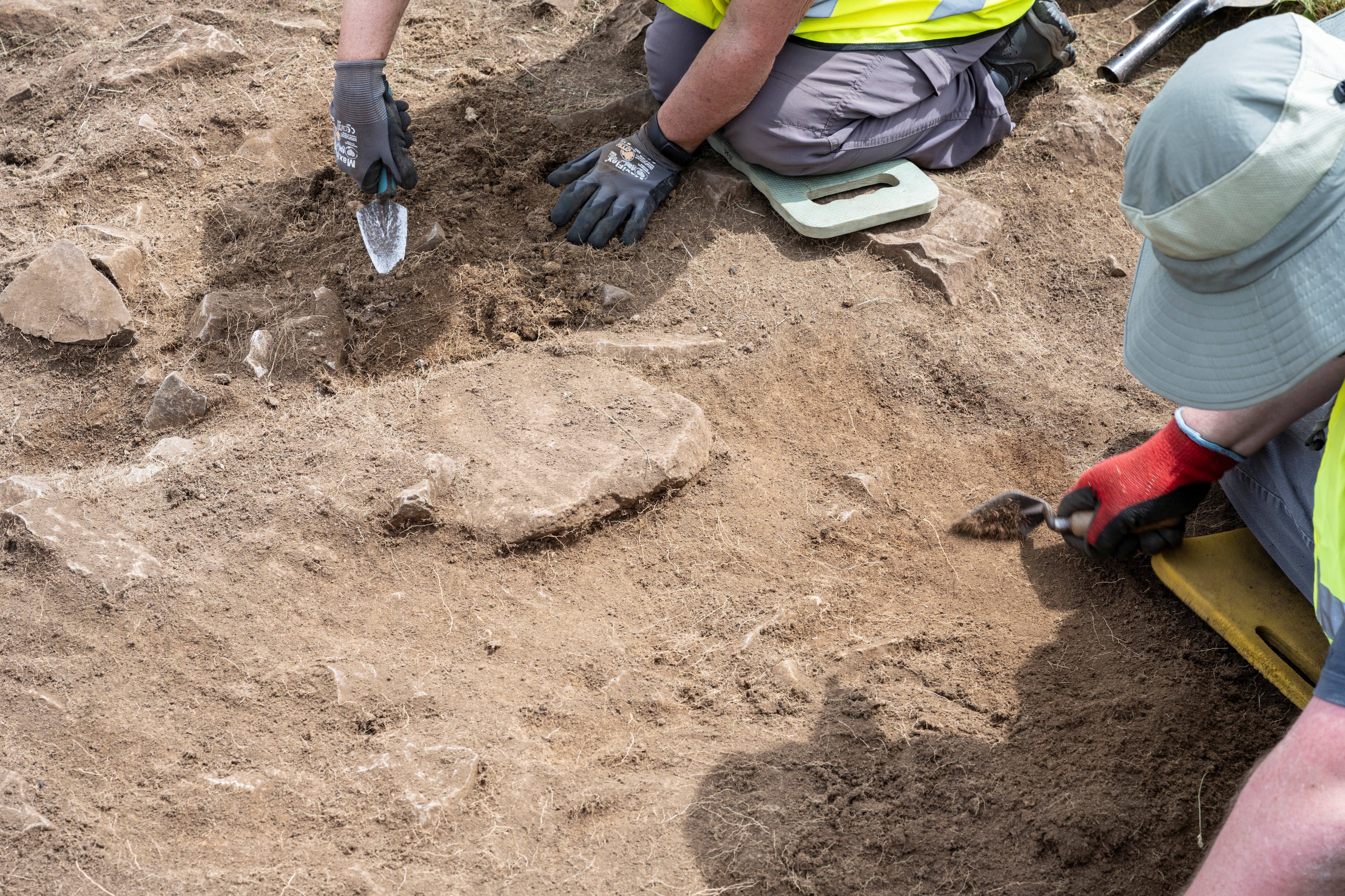 Volunteers take part in an archaeology excavation, at the Festival of Archaeology at Divis and the Black Mountain. They use , using trowels and other tools to carefully uncover remains.
