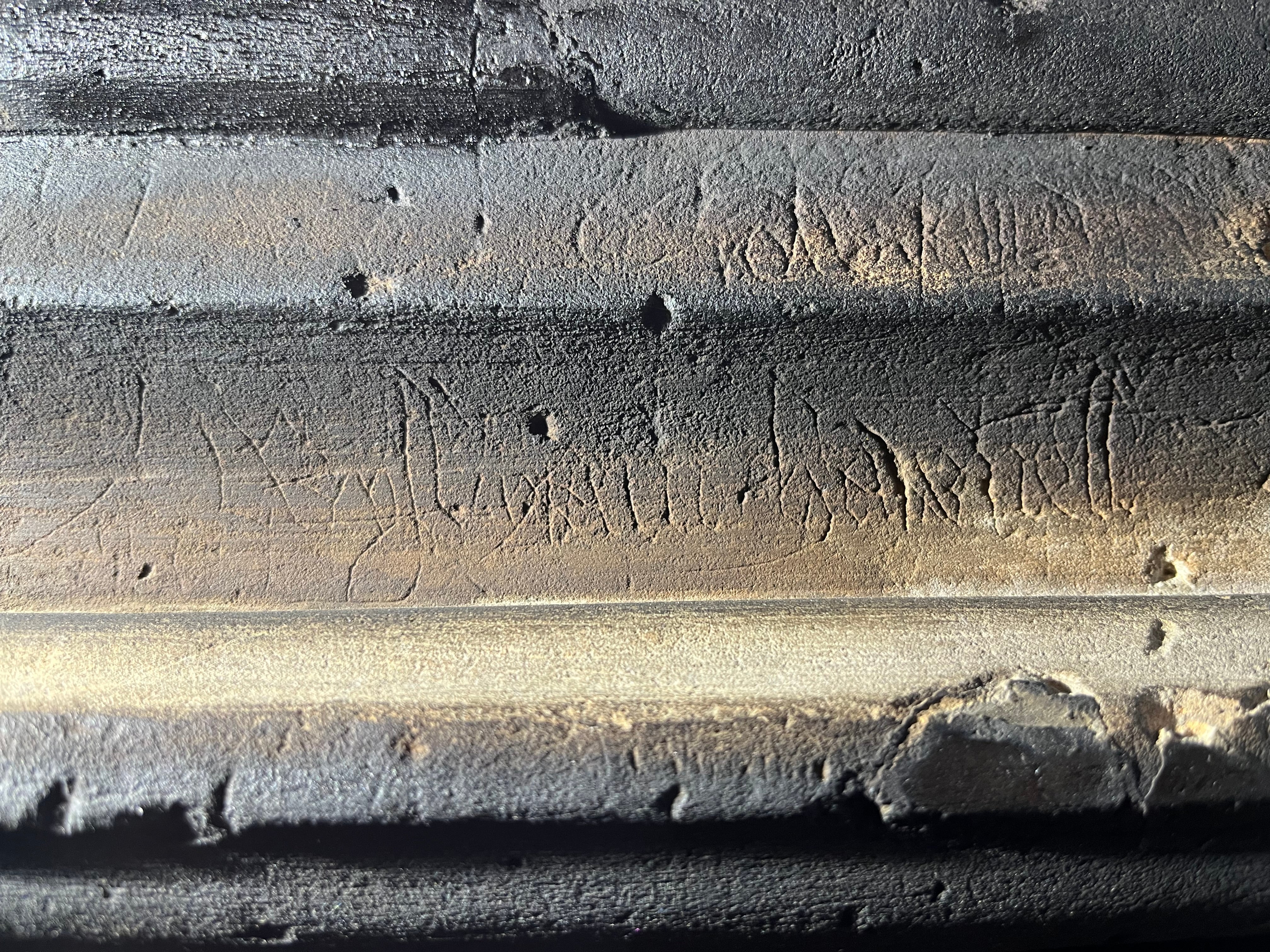 Early text, marks and engravings on the great hall stone fireplace at Stoneacre, Kent