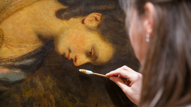 Conservator cleaning portrait painting by Sir Joshua Reynolds using a cotton swab