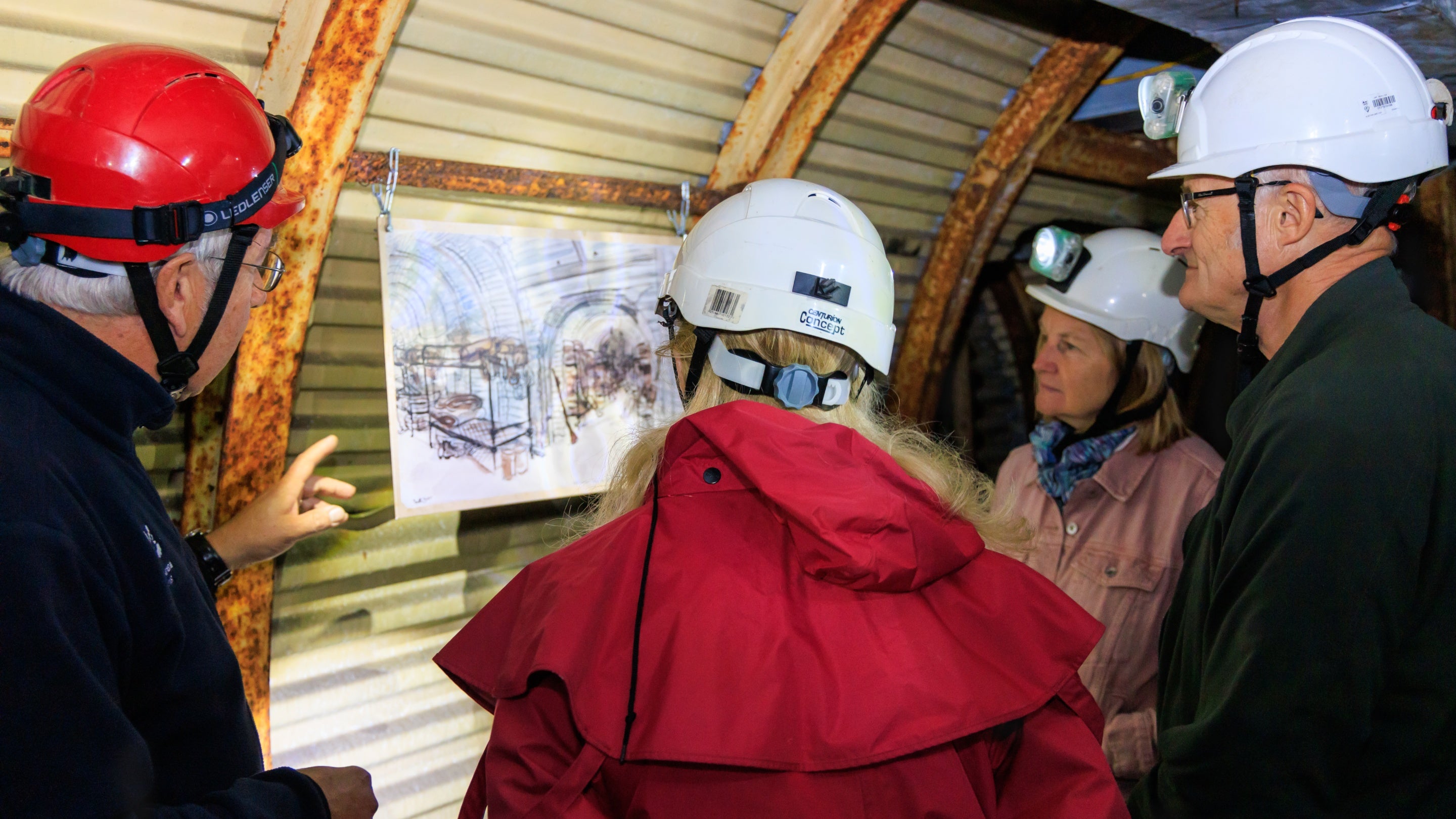 An image of a group of people viewing a Second World War sketch of the Fan Bay Deep Shelter tunnels.
