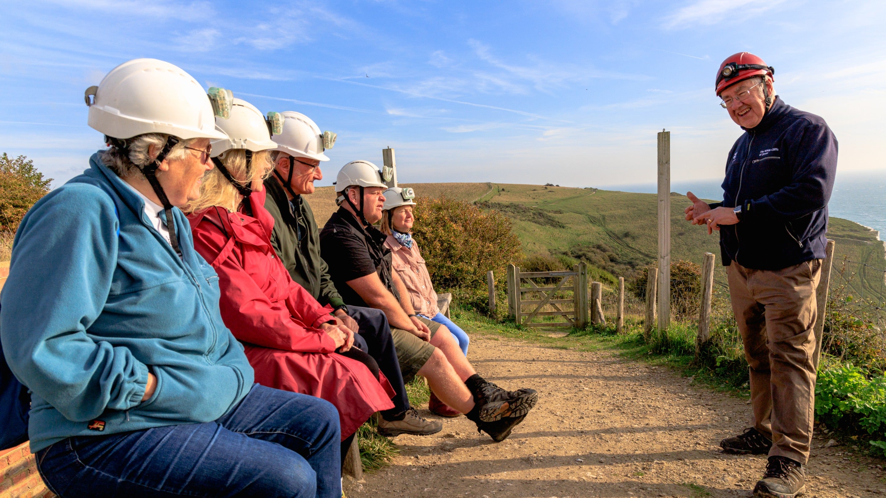 An image of visitors to Fan Bay Deep Shelter being briefed by their guide prior to descending into the tunnels on a sunny day