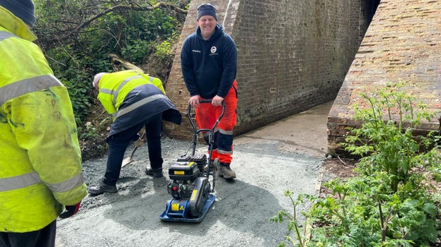 Image of a road being re-constructed using a vibrating plate