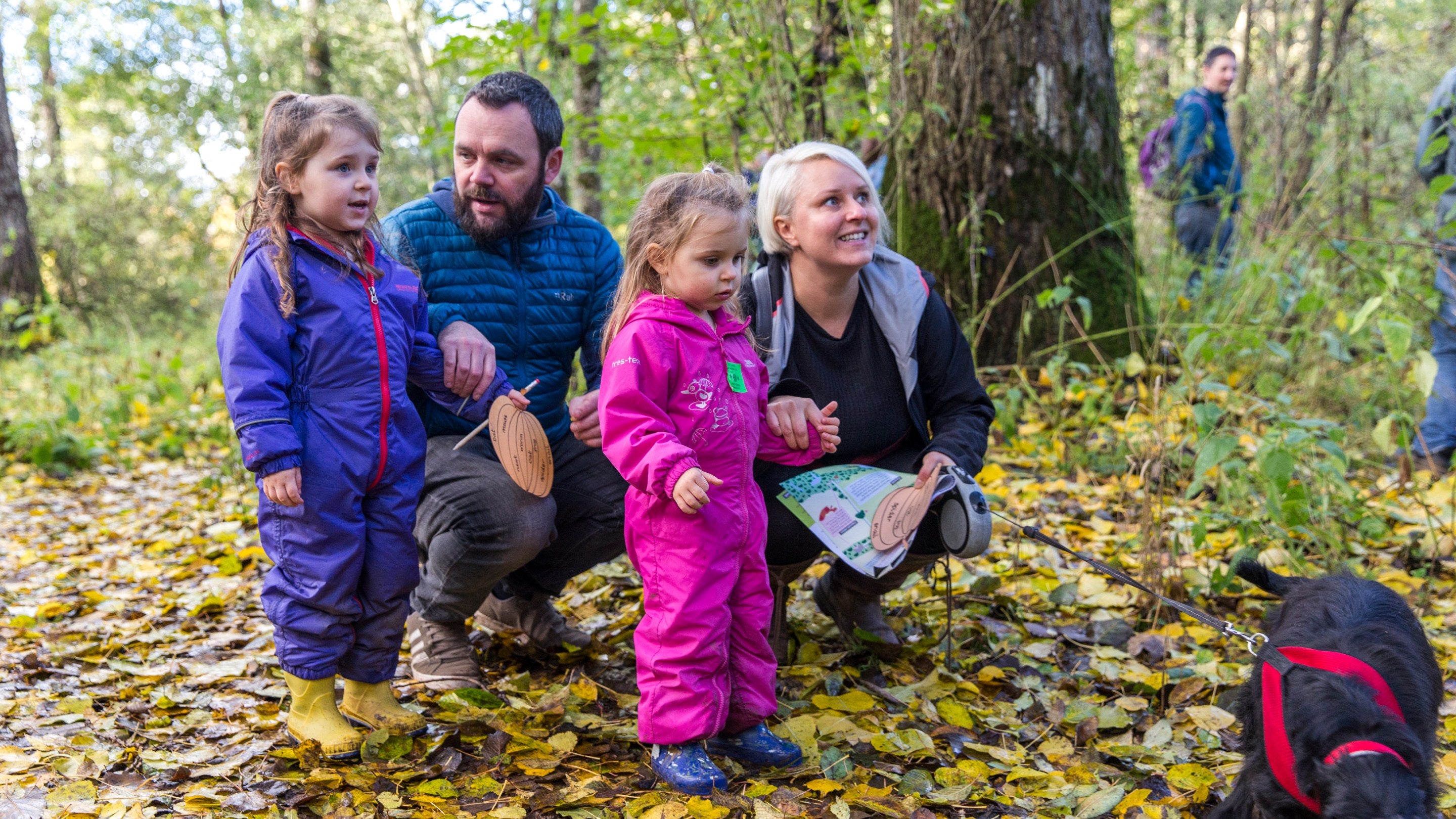 Visitors on a woodland walk family trail at Acorn Bank, Cumbria