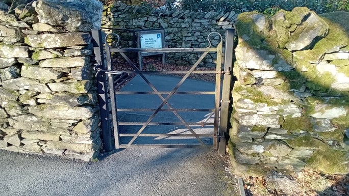Black metal gate in a drystone wall opening onto Allan Bank driveway, Allan Bank and Grasmere, Cumbria