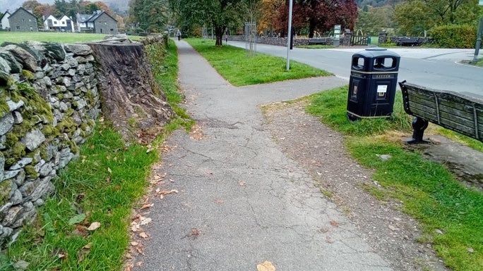 Bumpy tarmac next to an old tree stump and footpath junction, Allan Bank and Grasmere, Cumbria