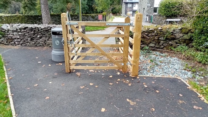 At the end of the footpath, a wooden gate leads onto the main road, Allan Bank and Grasmere, Cumbria