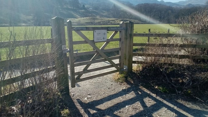 Wooden gate onto a footpath next to a field, Allan Bank and Grasmere, Cumbria