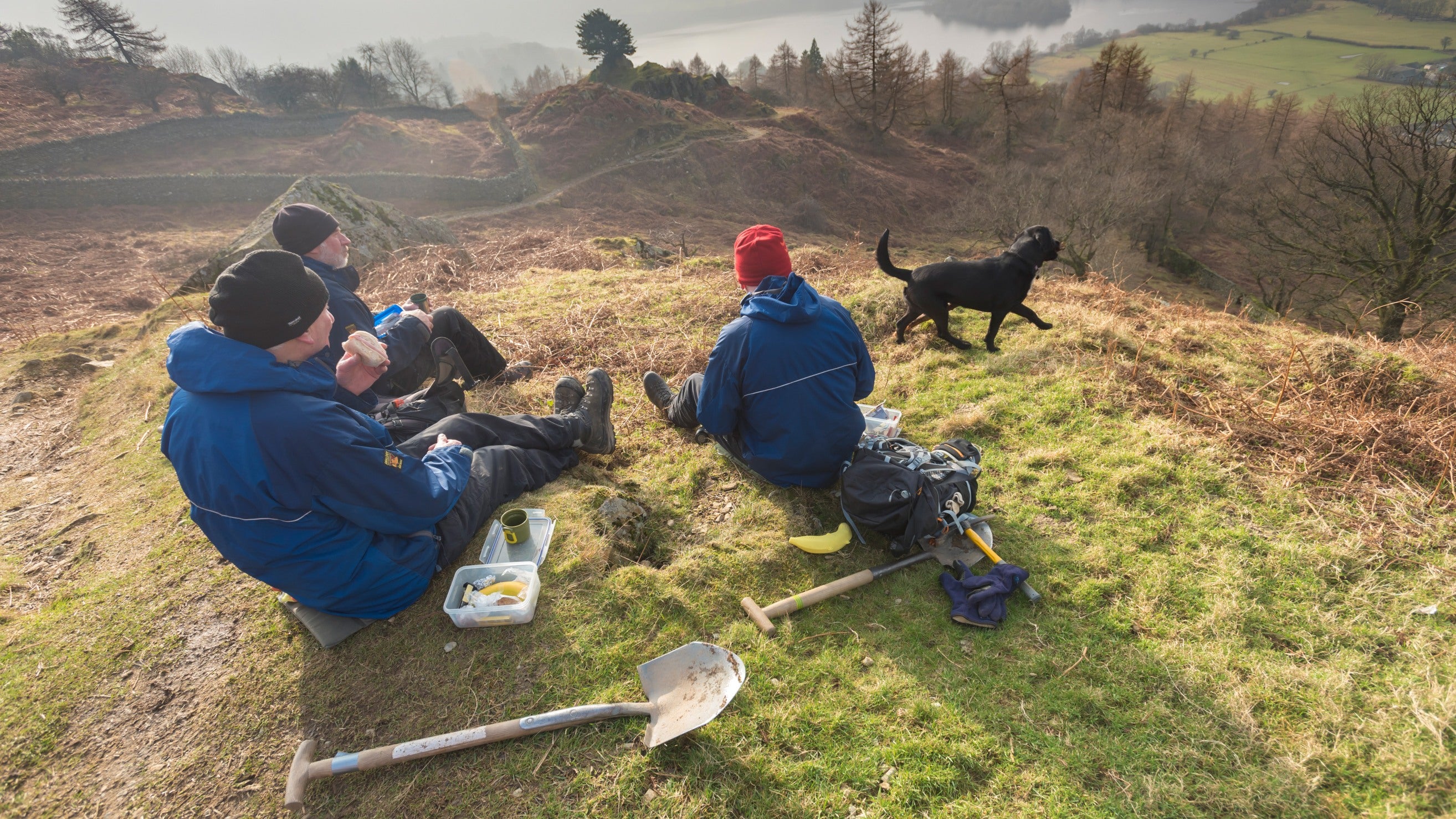 Rangers and volunteers having a well-earned rest while helping to clear pathway drainage on the fells above Grasmere, Cumbria