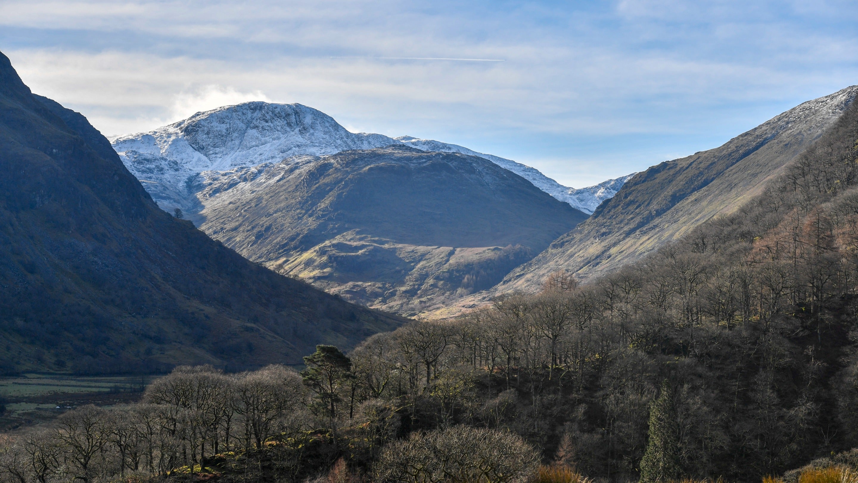 A view of Seatoller farm and snow capped fells in the Borrowdale Valley in winter.