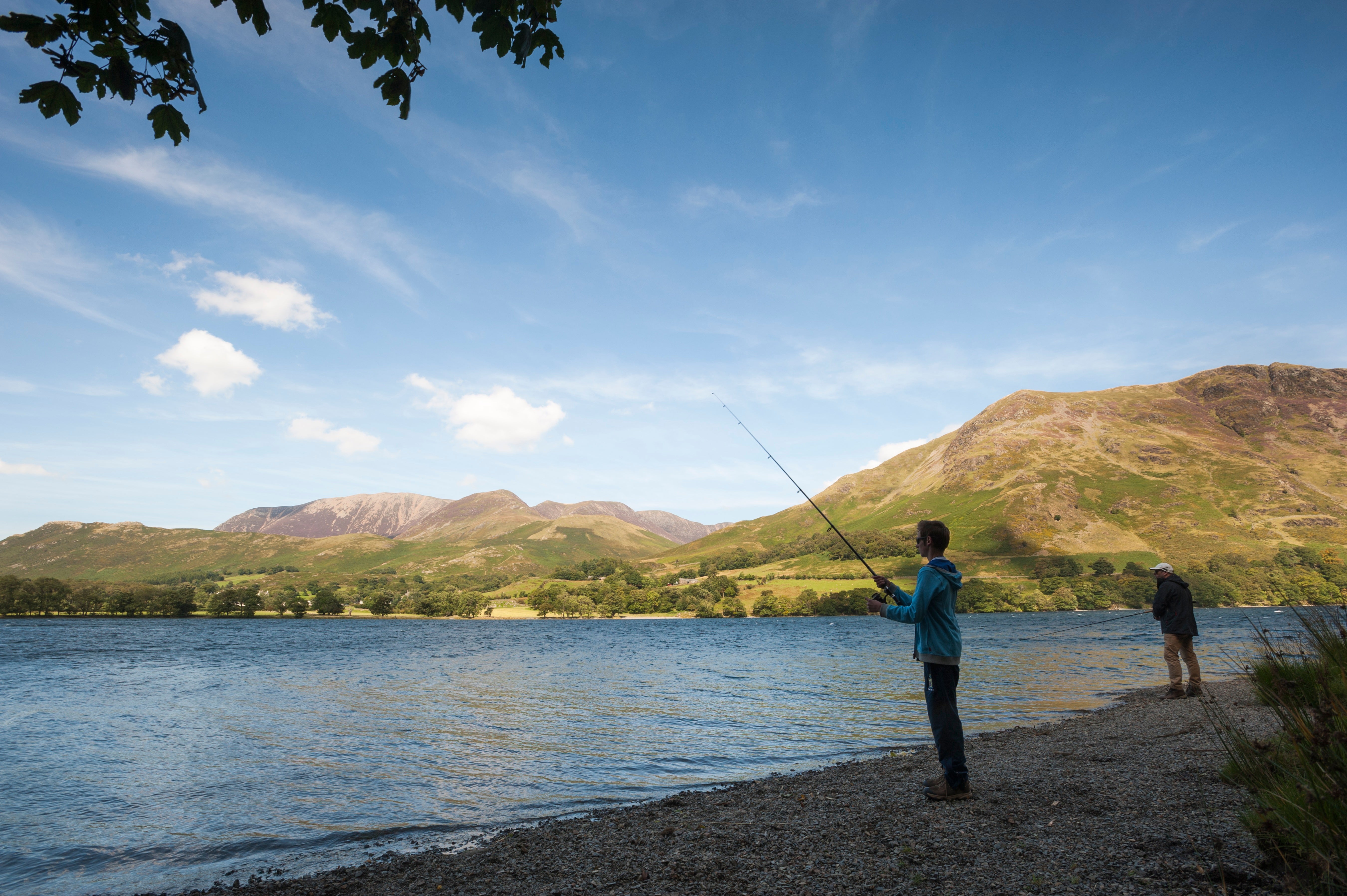 Person fishing on shingle shores of Buttermere