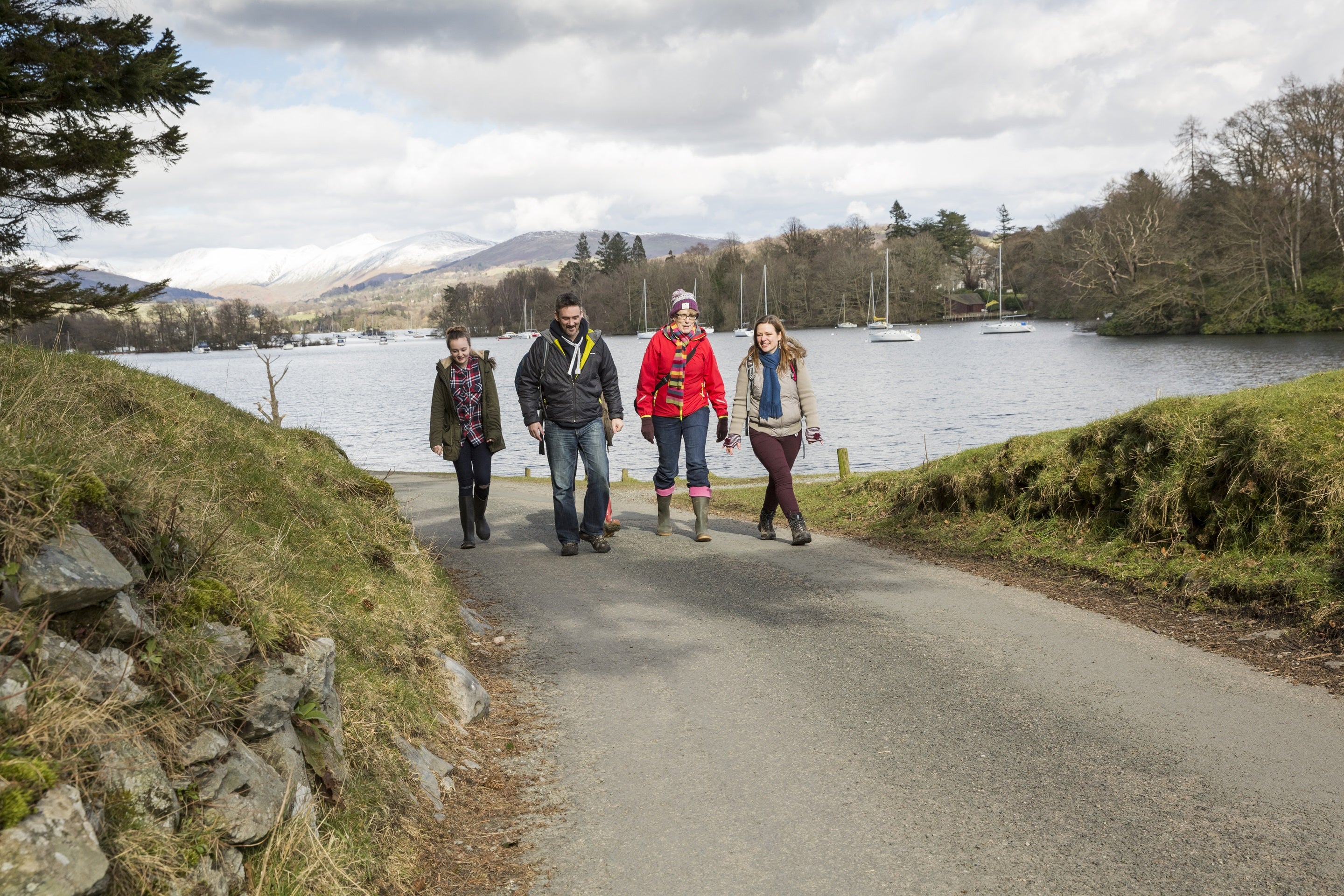 Four visitors walking along the shore of Windermere in the winter time