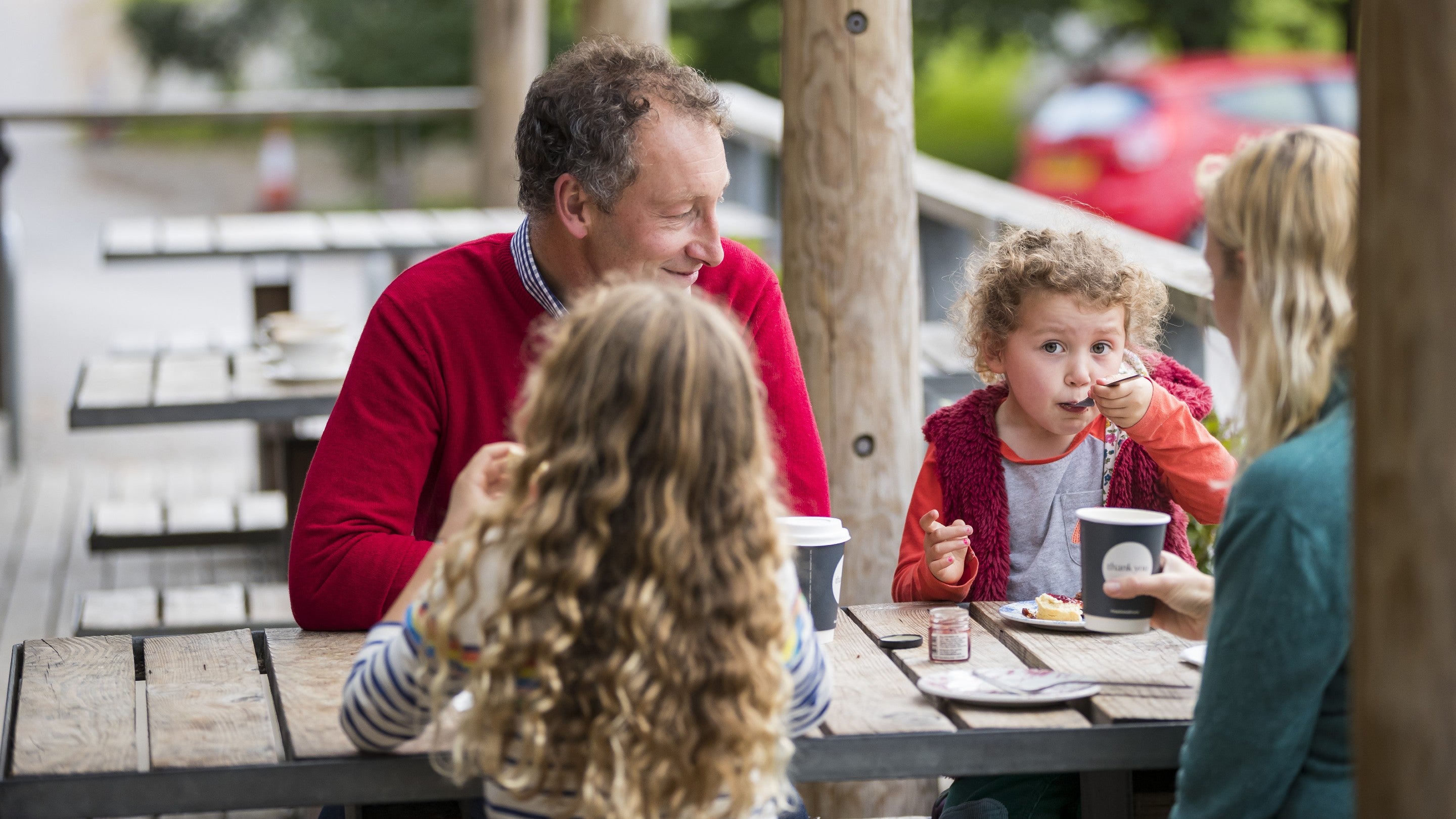 Family enjoying tea and scones on the veranda outside the cafe at Sizergh Castle, Cumbria