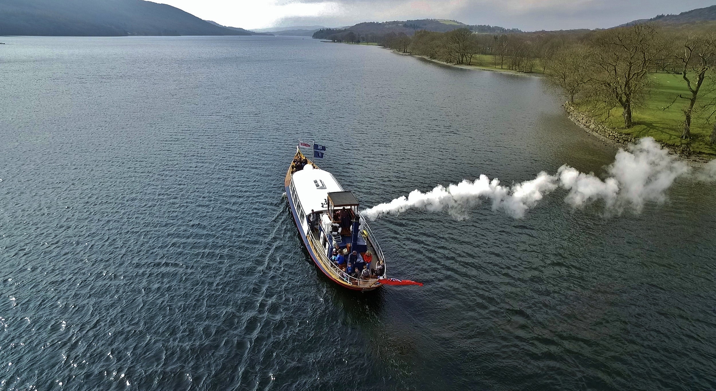Drone shot from the air looking down at Steam Yacht Gondola sailing up Coniston