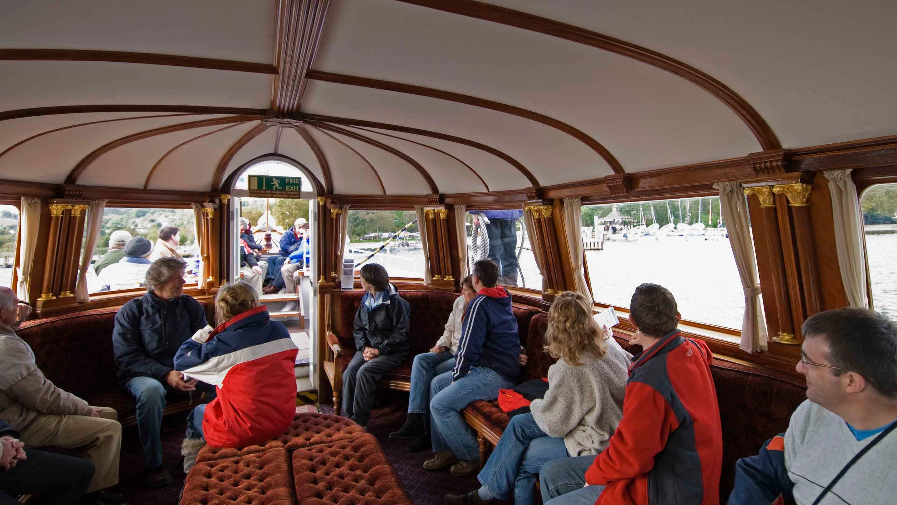 Passengers in the cabin of Gondola, a rebuilt Victorian steam-powered yacht on Coniston Water, Lake District, Cumbria
