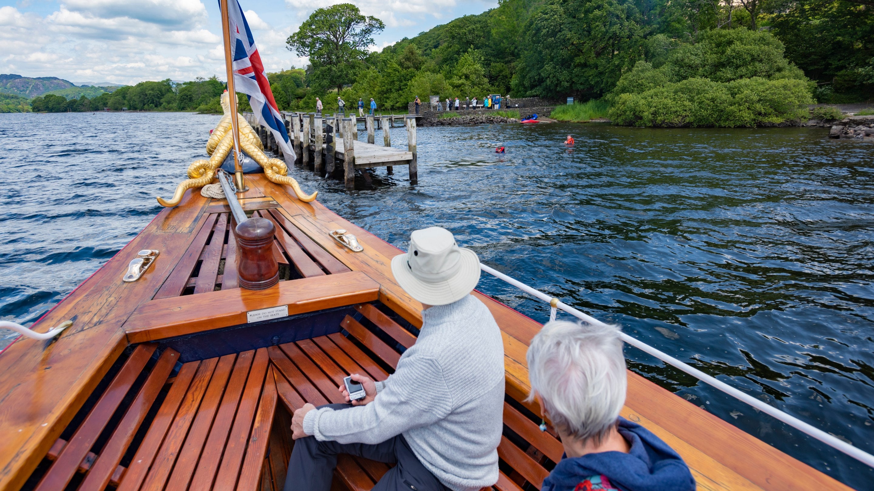 Passengers aboard the Gondola, a rebuilt Victorian steam-powered yacht, on Coniston Water, Lake District
