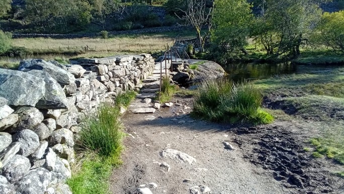 Gravel footpath leading to a stone bridge over the river, Little Langdale, Cumbria