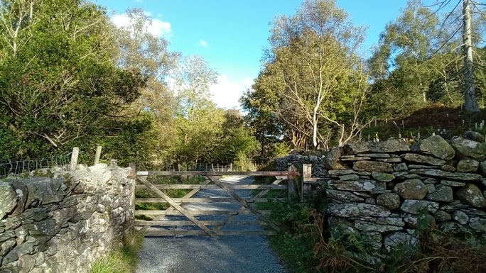 A wooden gate across the gravel footpath lined by two drystone walls, Little Langdale, Cumbria