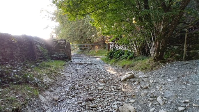 Loose and large boulder footpath with a metal gate across it and a path junction, Elterwater, Cumbria