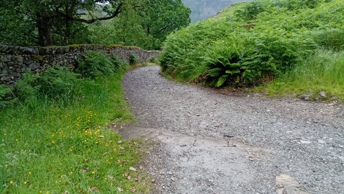 Gravel path with a drystone wall on the left and a grassy banking on the right, Hodge Close, Cumbria
