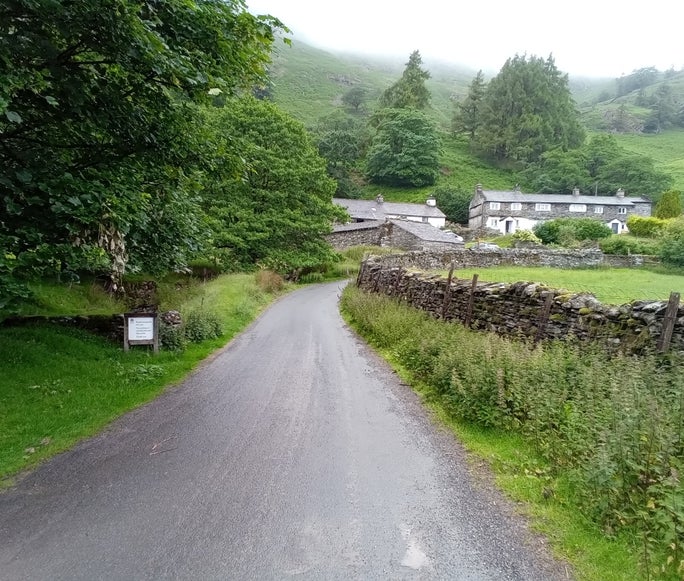 Tarmac road with stone cottages and a drystone wall, Tilberthwaite, Cumbria