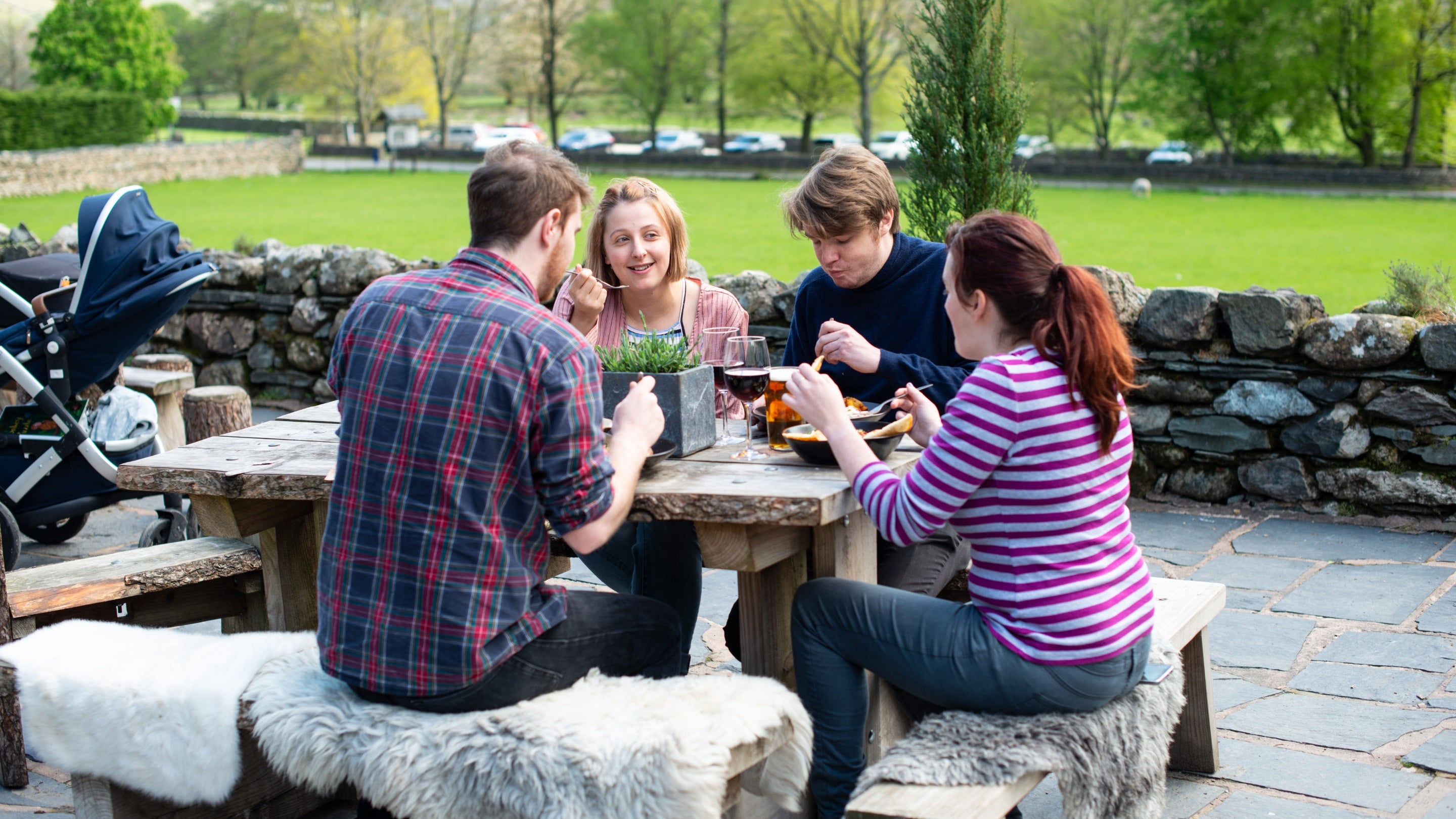 Visitors eating outside at the Sticklebarn Pub in the Langdales, Lake District