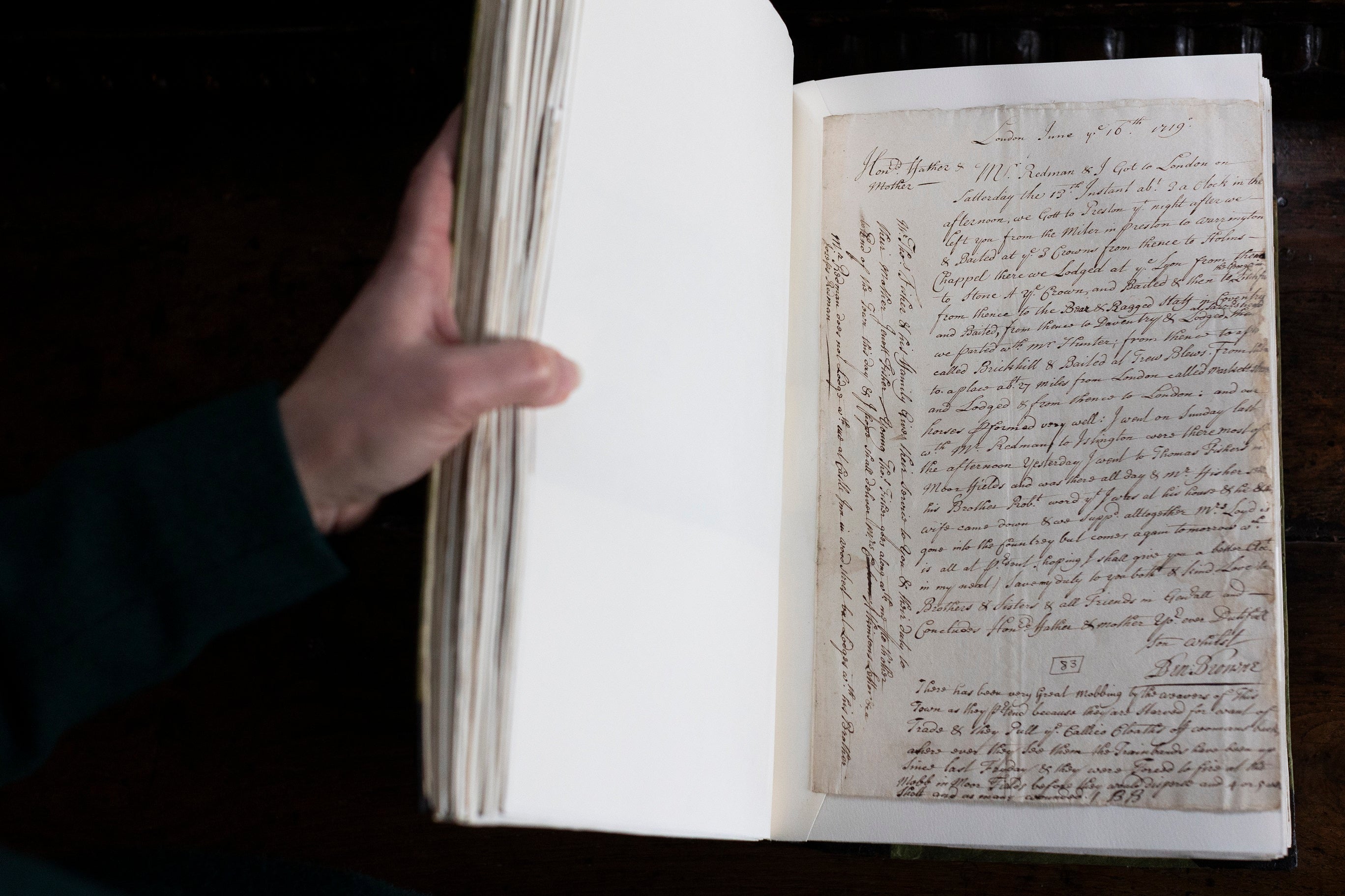 A hand holding the page of an old letter